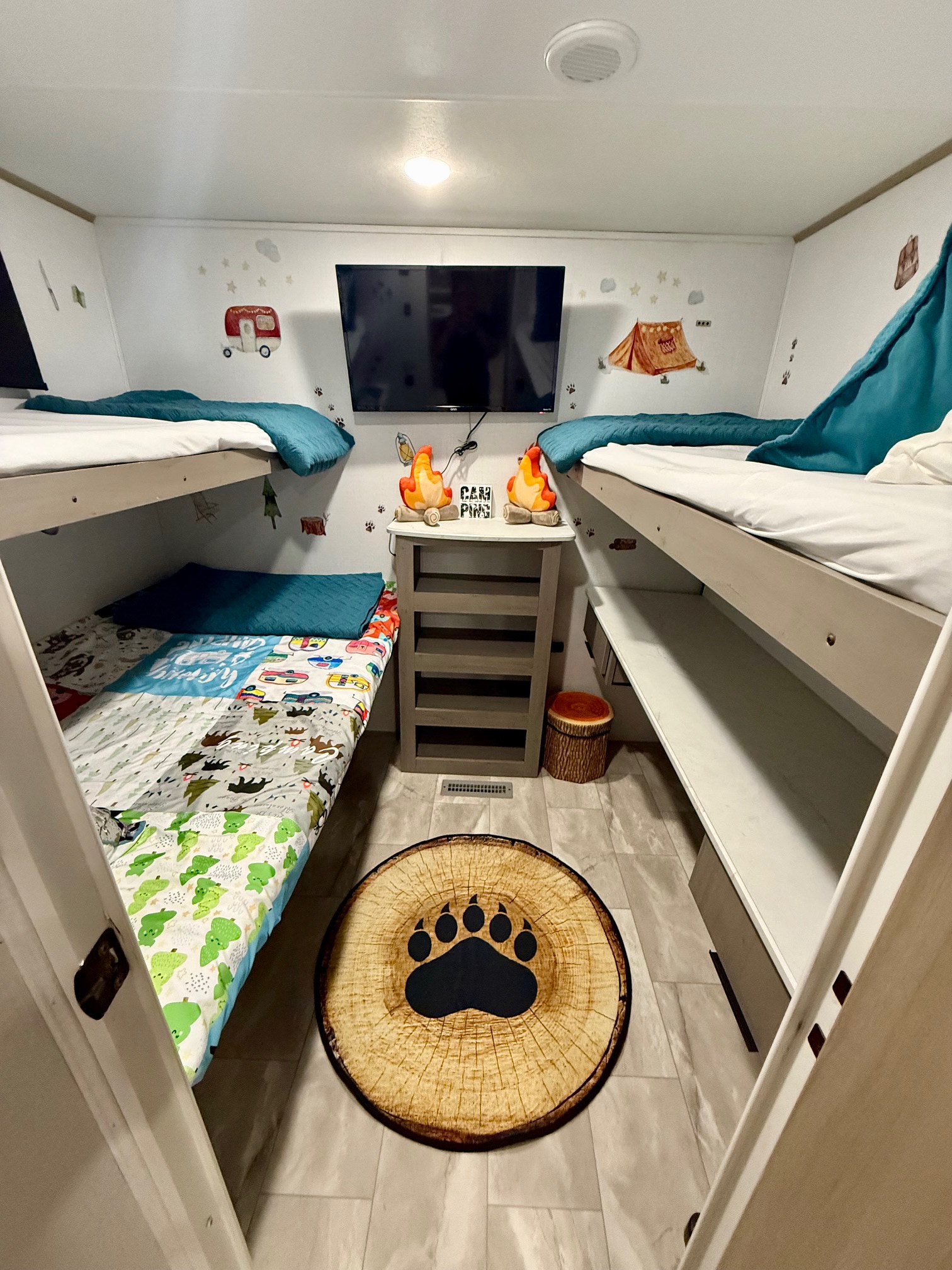 Cozy RV rental bunk room with fun camping decor, including themed bedding, TV, and paw print rug. Ideal for family travel.. Dutchmen Kodiak Ultra Lite 2025