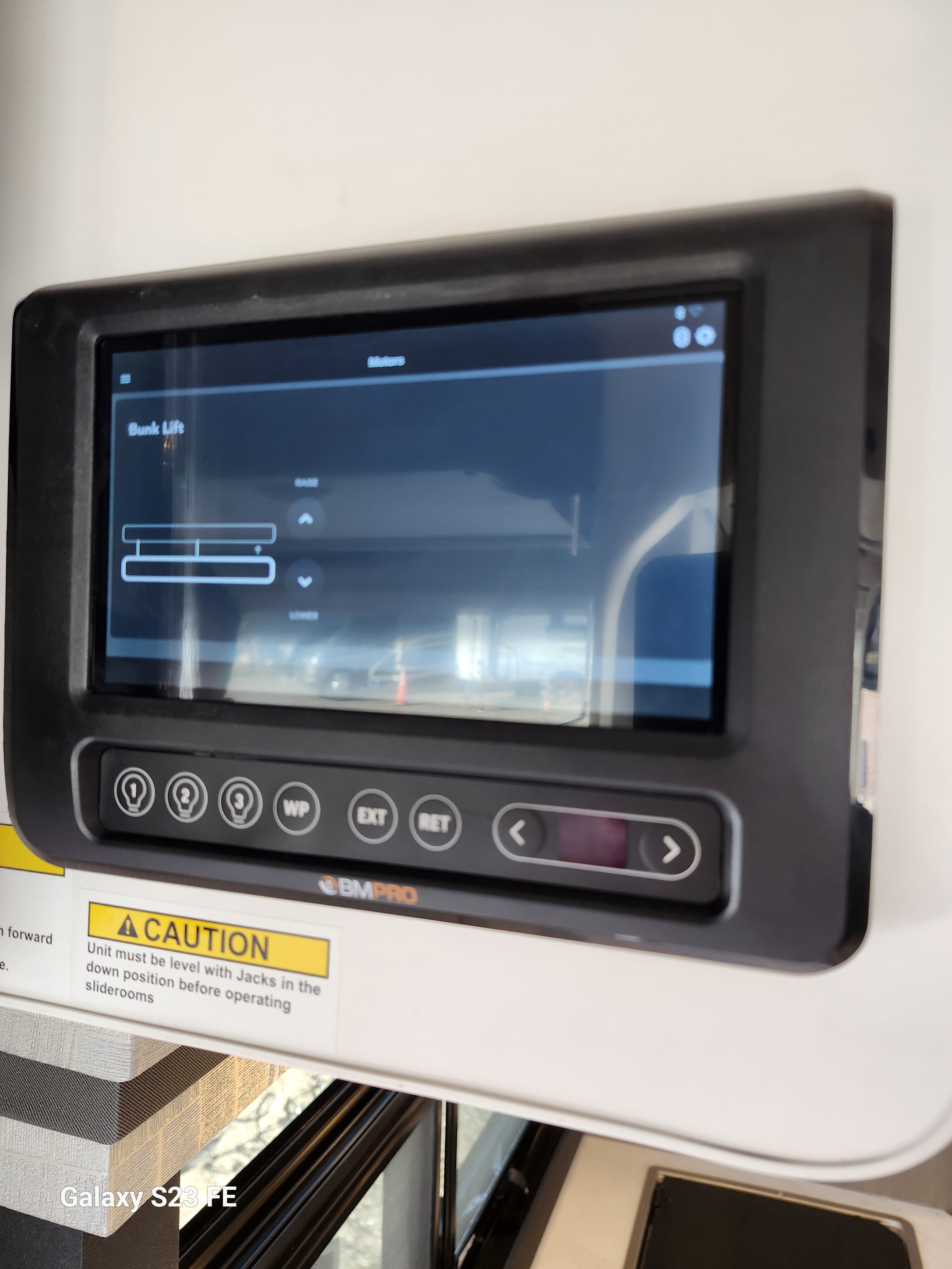 RV rental control panel showing bunk lift screen, light buttons, and slide-out extend/retract controls for managing the RV.. Axis 24.1 2026
