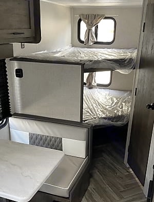 Experience comfort in this rv rental. Features bunk beds with plastic-covered mattresses and a dinette seating area.. Forest River Salem 179 2021