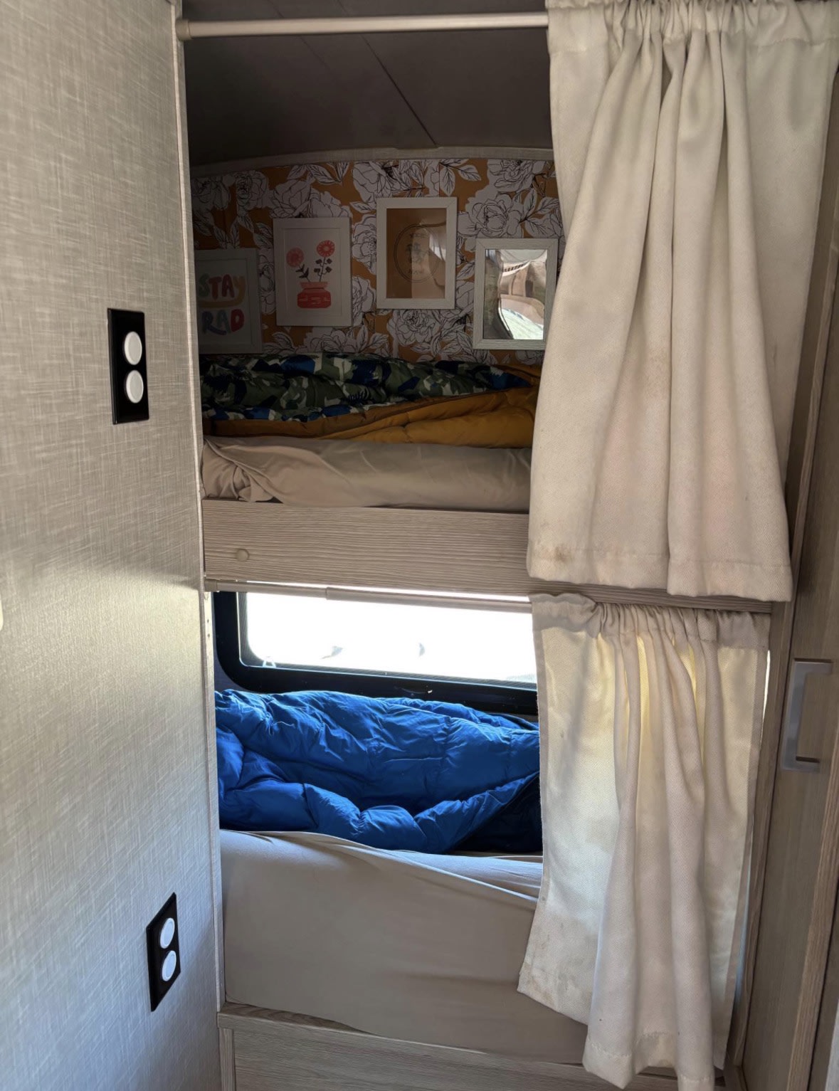 Cozy rv rental bunk beds with privacy curtains. Top bunk has floral wallpaper & art, bottom bunk a window. Ideal for travelers.. Rock wood Geo Pro Geo pro 16BHS 2022