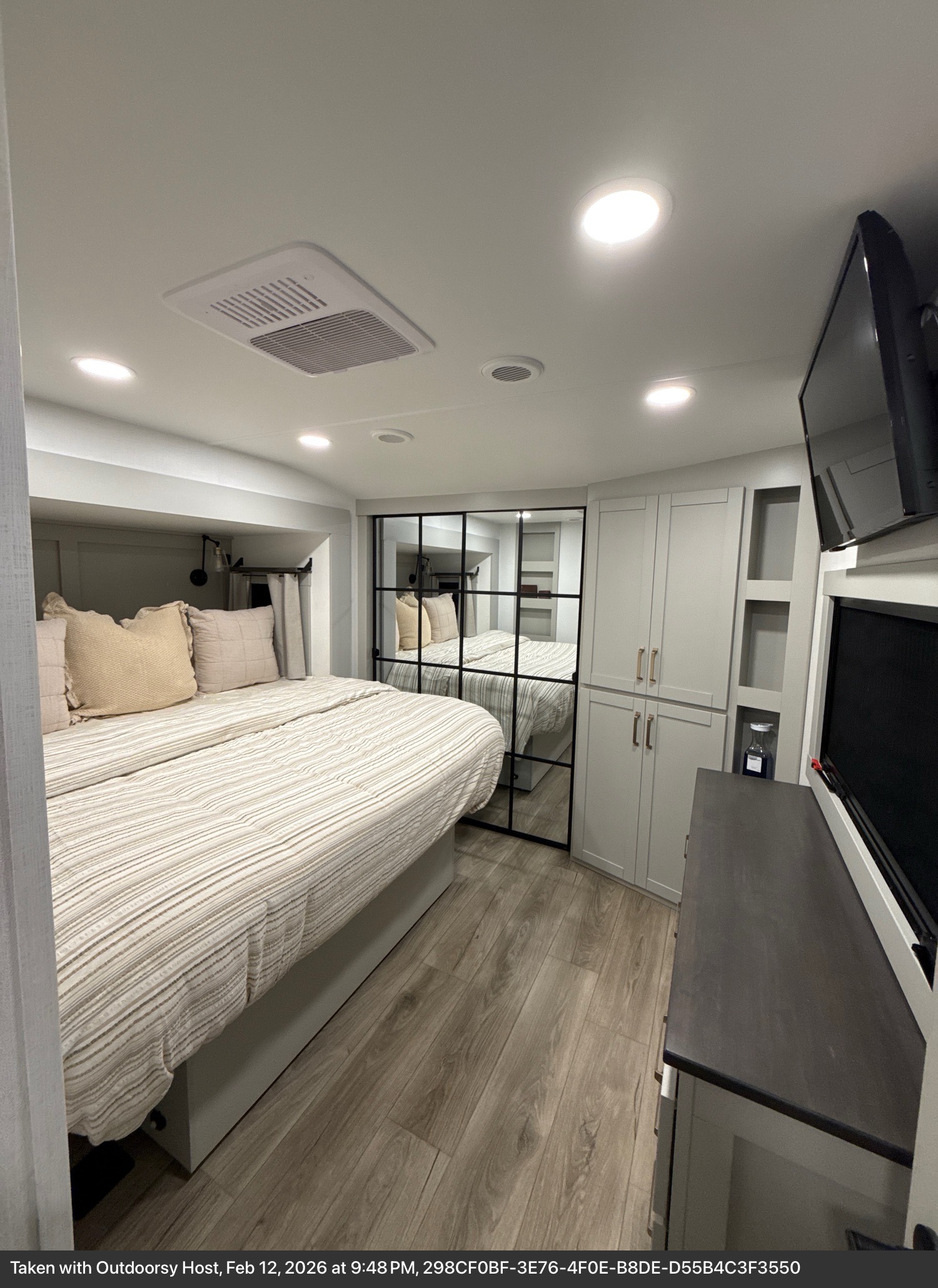 Bright and compact RV rental bedroom with a comfy bed, integrated storage, and mirrored closet doors for a spacious feel.. Brinkley RV Model Z 2025