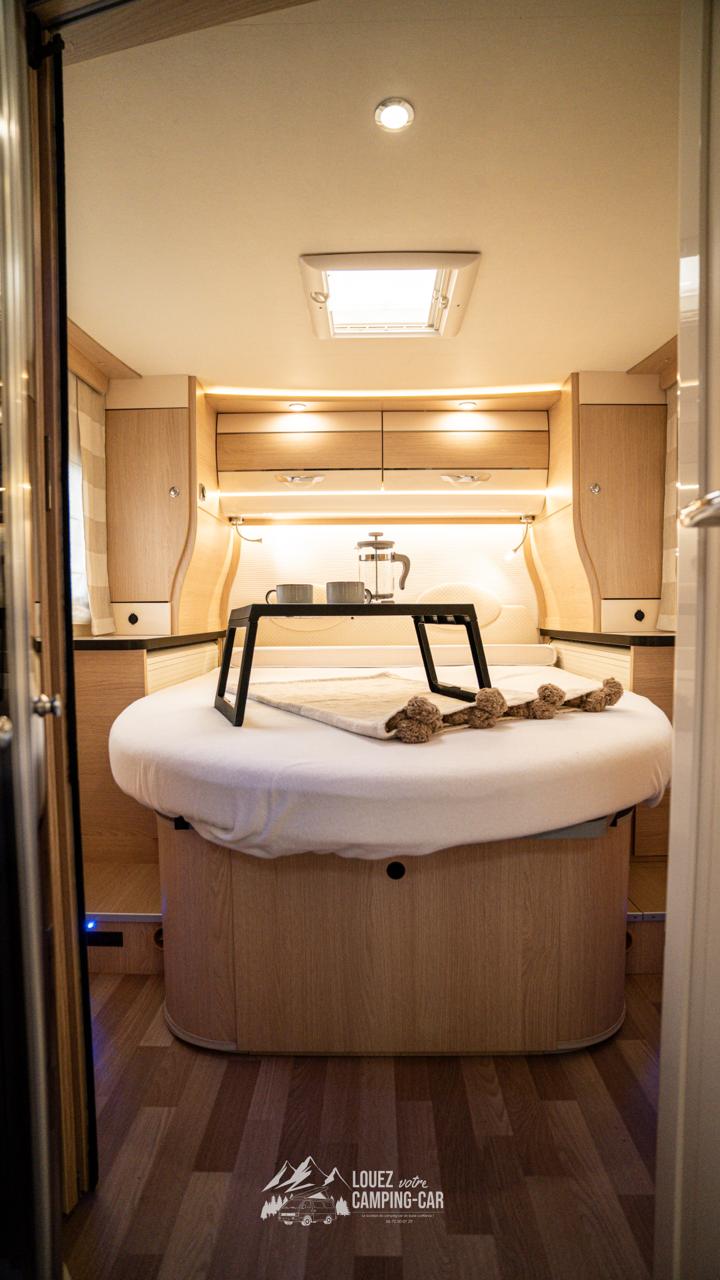 RV rental: Modern and cozy RV bedroom with a round bed, breakfast setup, warm lighting, and wood accents.. AUTOSTAR i730 2022