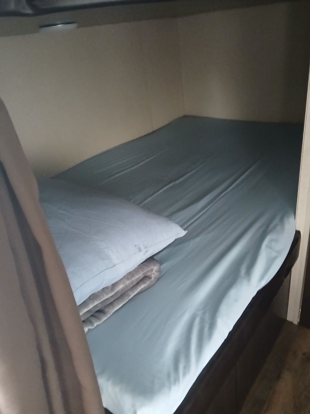 Comfortable RV rental bunk bed with light blue sheets, pillow, and folded blanket for a restful sleep.. Xlite 261BHXL 2019