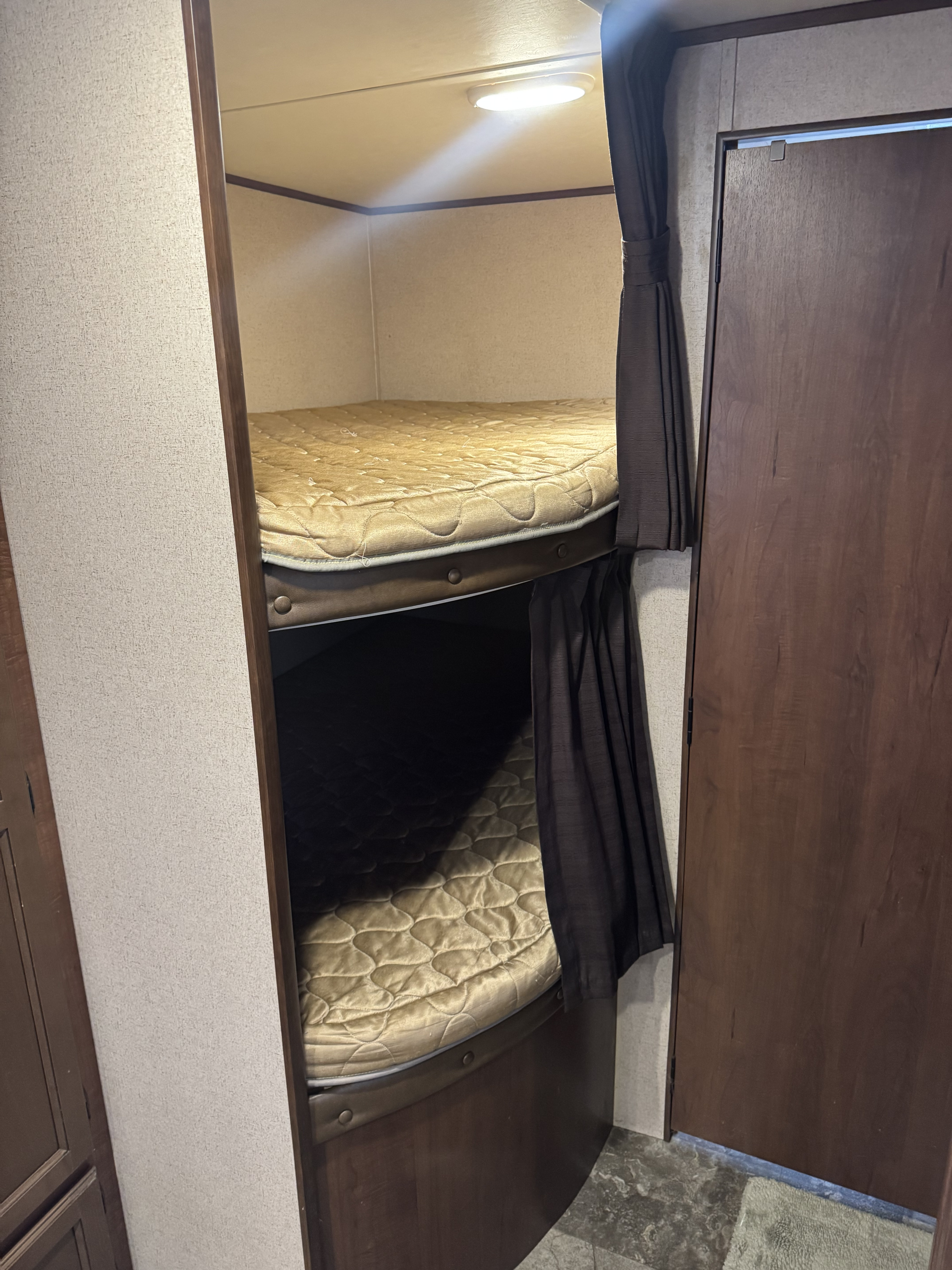 RV rental bunk beds feature quilted mattresses, privacy curtains, and overhead lighting, offering compact sleeping space for trips.. Jayco Jay Flight 2015