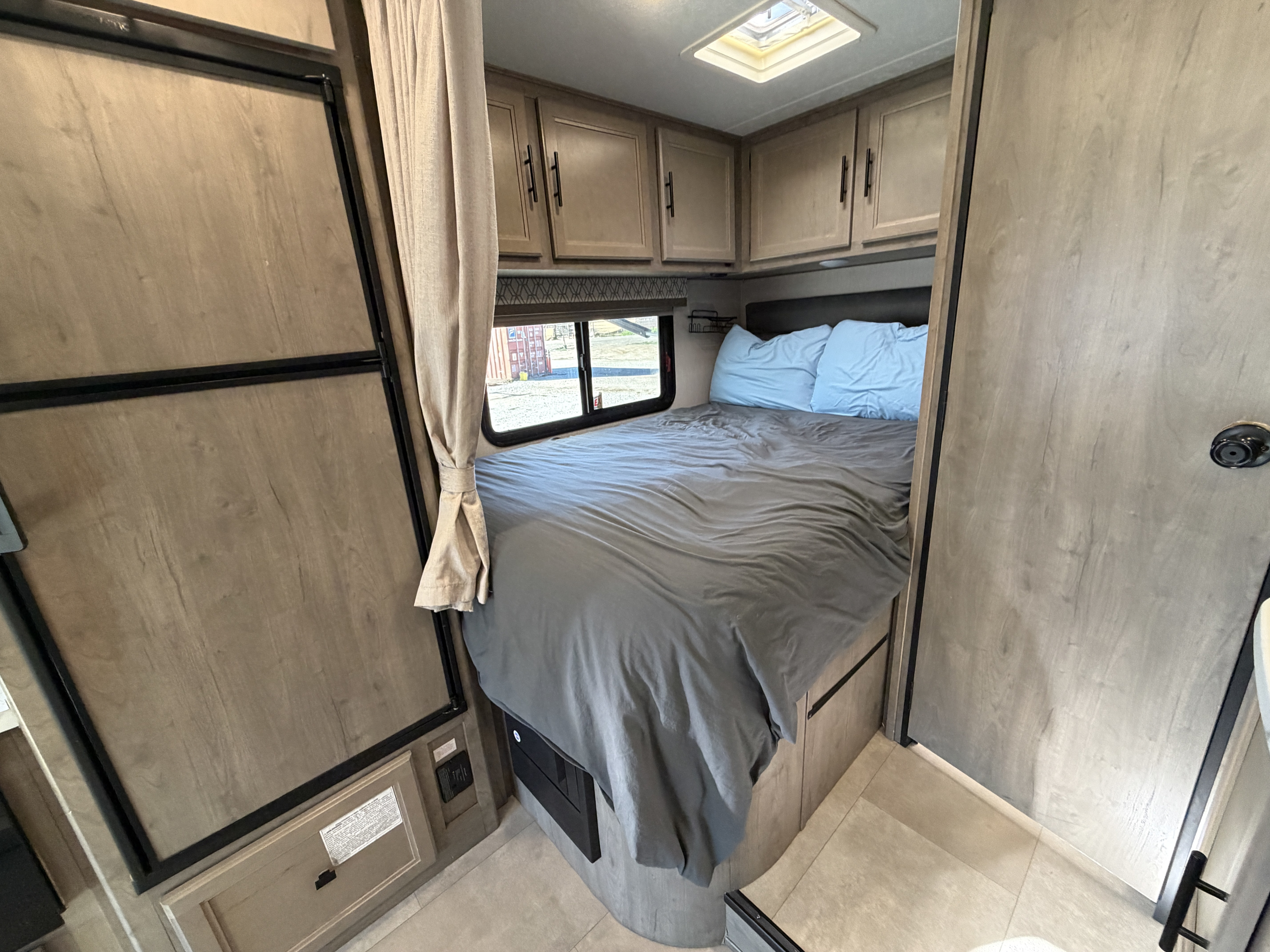 Spacious RV rental bedroom with a cozy bed, ample storage, and natural light from the skylight and window.. Coachmen Other 2020
