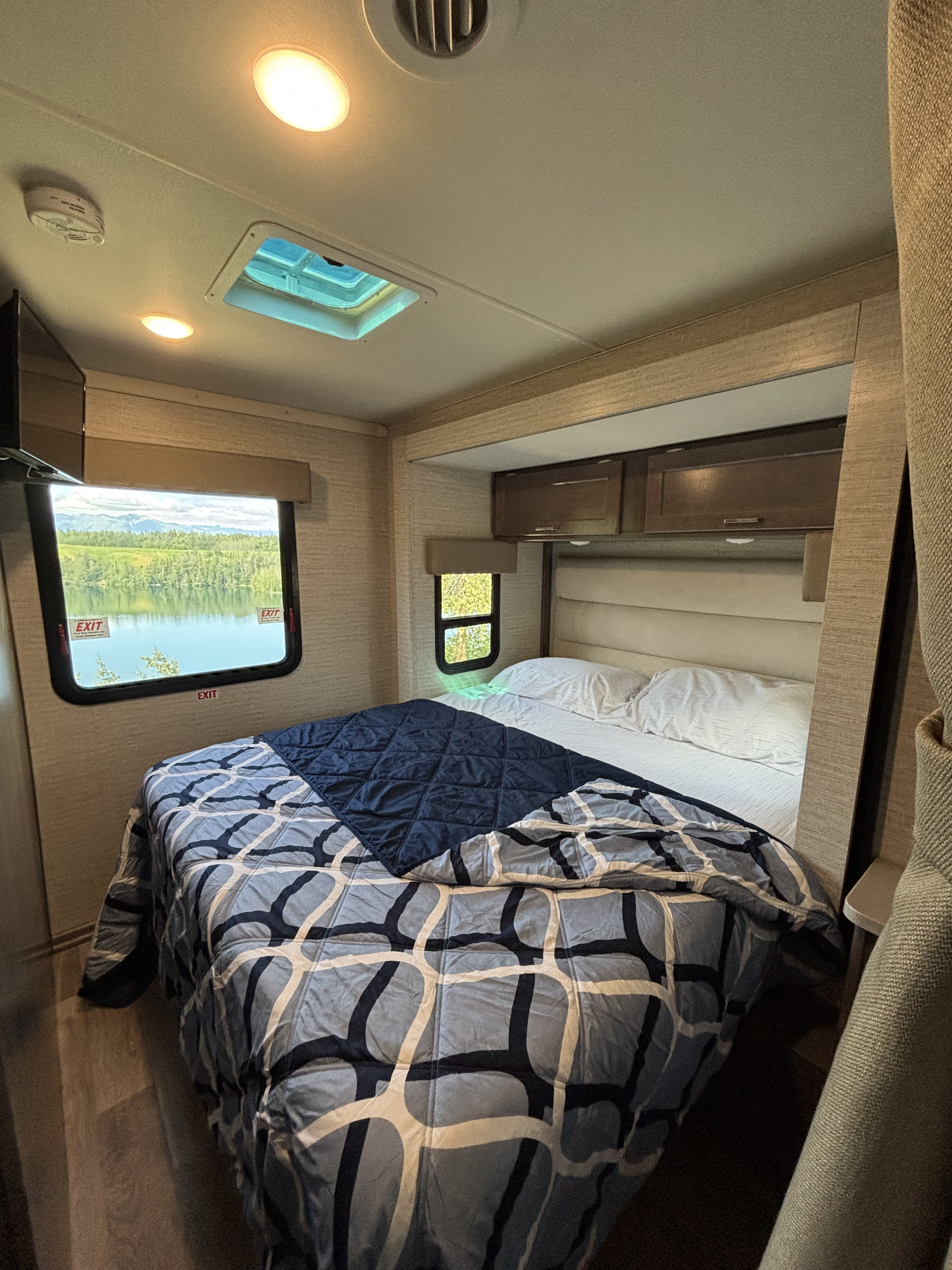 RV rental bedroom interior: comfortable bed, skylight, and scenic lake & mountain view from windows.. Winnebago Minnie Winnie 2023