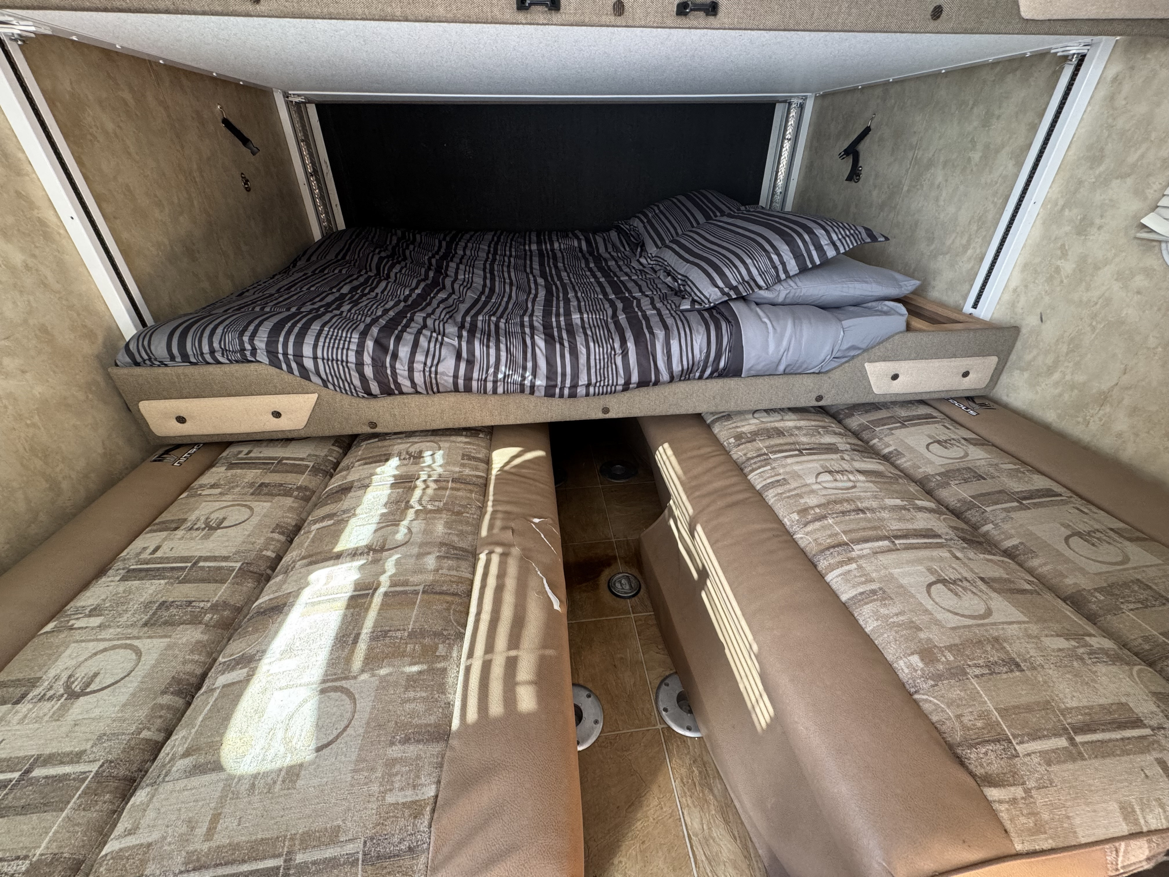 RV rental interior featuring a drop-down bunk bed with striped bedding and a convertible dinette below for extra sleeping or seating.. Fleetwood Nitrous Hyperlite 190FK 2007