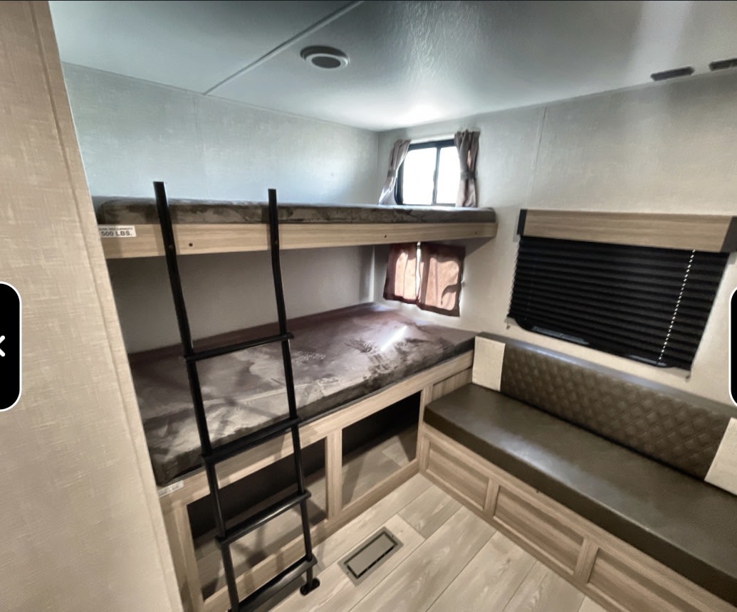 RV rental interior: comfy bunk beds with ladder and ample bench seating for your next adventure.. Kz Sportsmen 332bhkse 2026