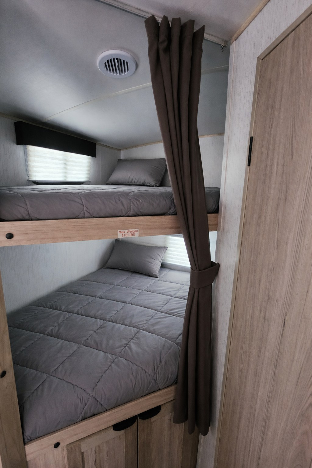 Cozy RV rental bunk beds, perfect for family travel. Features privacy curtain, window, and ceiling vent.. Heartland RVs Cruiser 2022