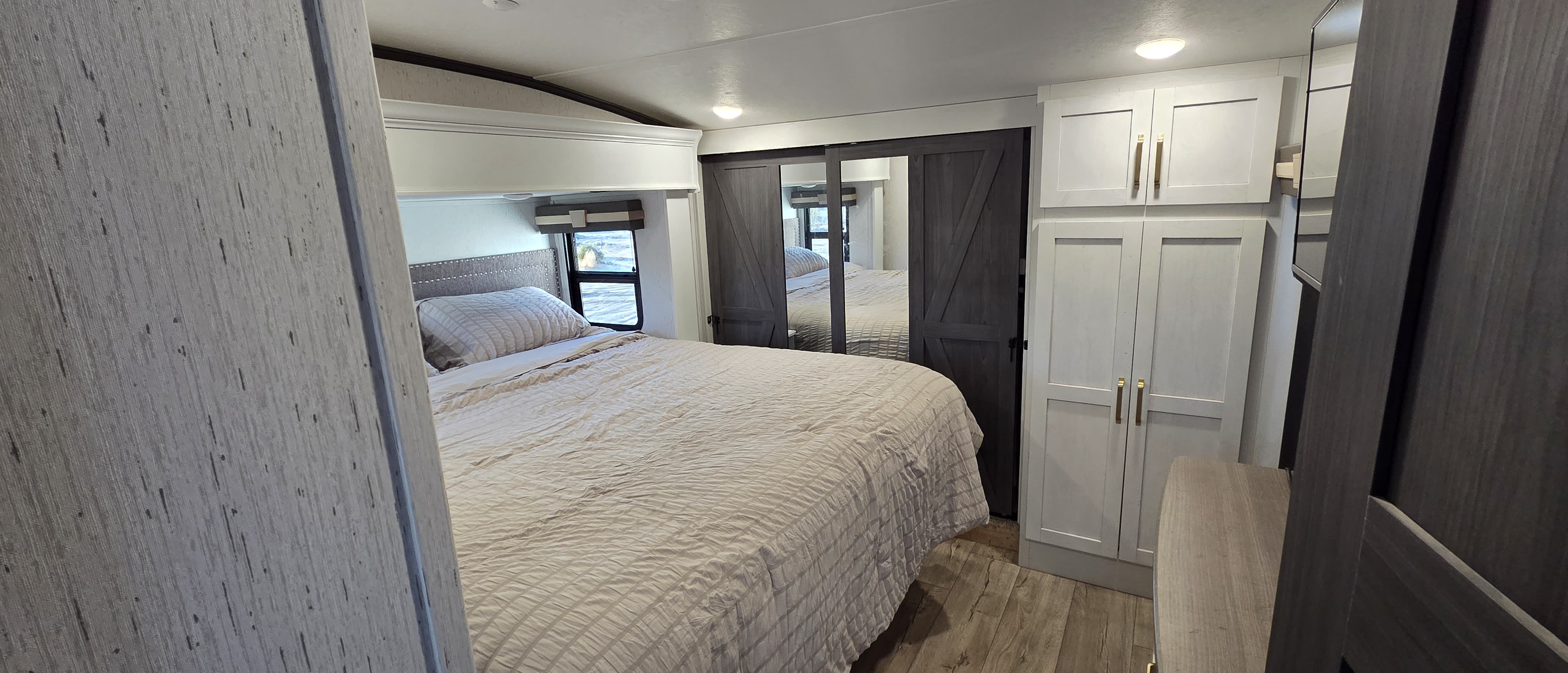 RV rental bedroom featuring a comfy bed, modern mirrored closet, and ample storage. Perfect for your next trip.. Astoria Astoria Fifth Wheel 2023