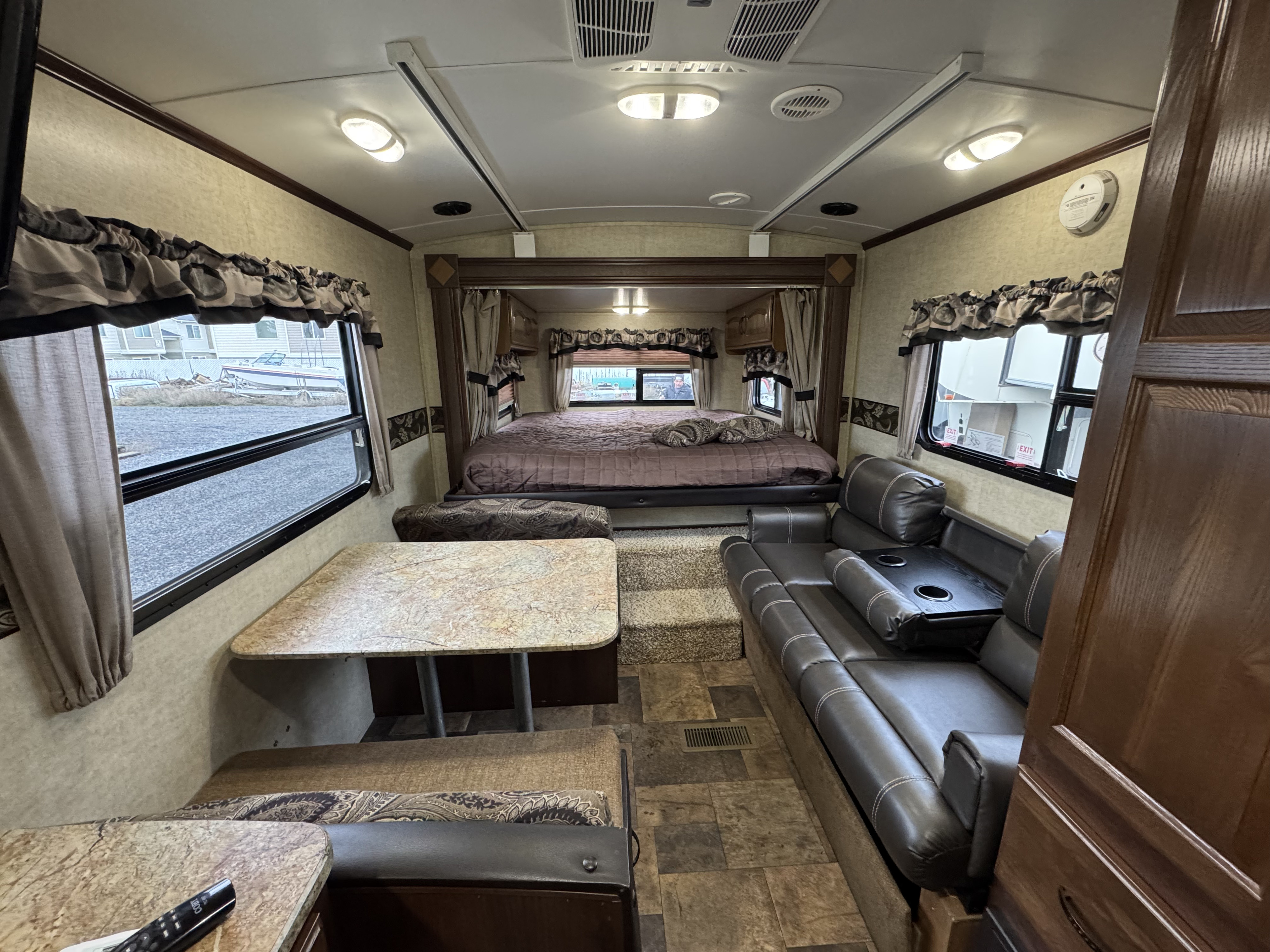 This inviting rv rental interior showcases a cozy bedroom, a dinette, and a reclining sofa for comfortable travels.. Keystone RV Outback Toy Hauler 2013