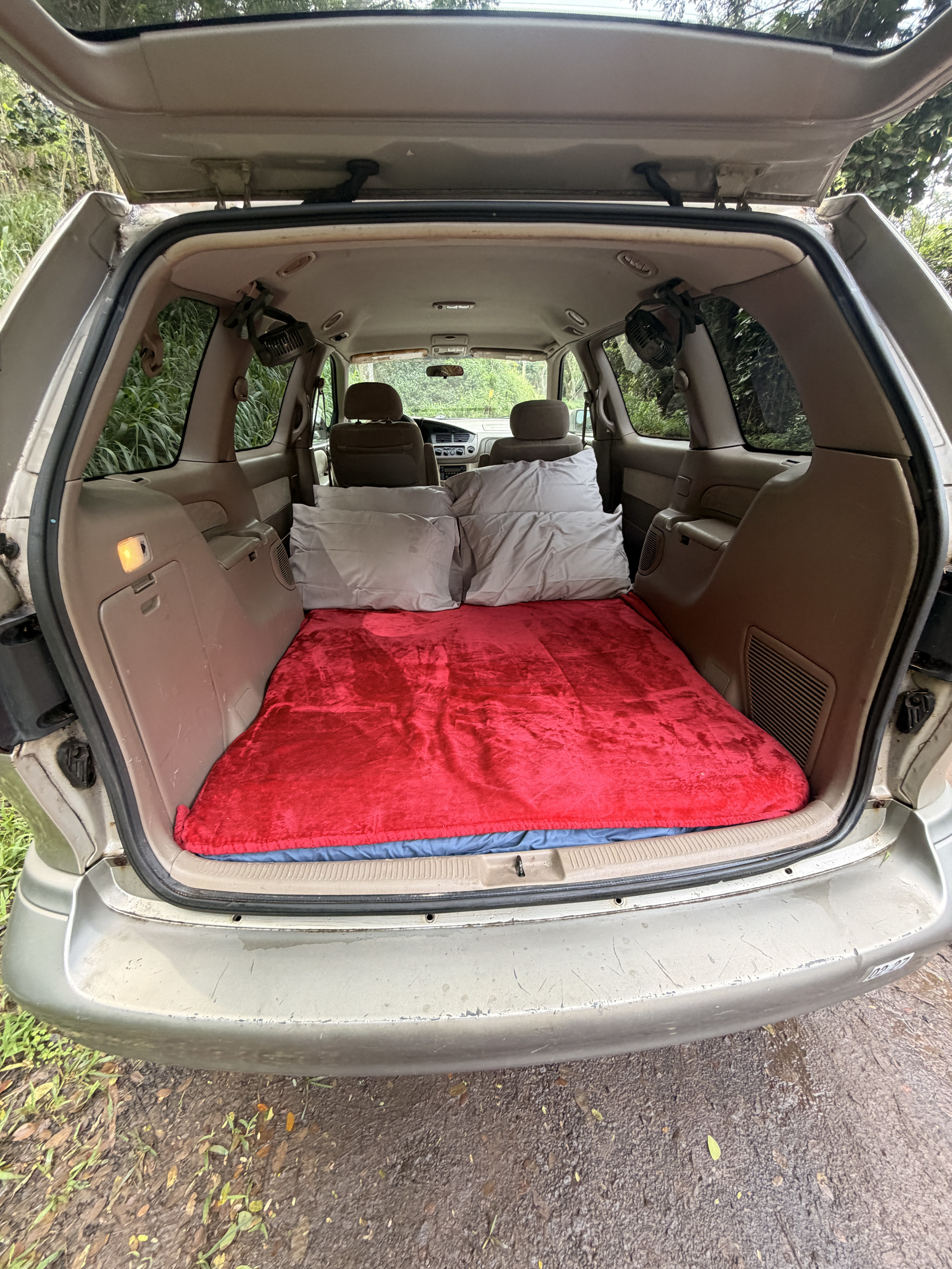 Explore in comfort with this minivan camper! A cozy sleeping setup, ideal for an RV rental or car camping trip.. Toyota Sienna 2002