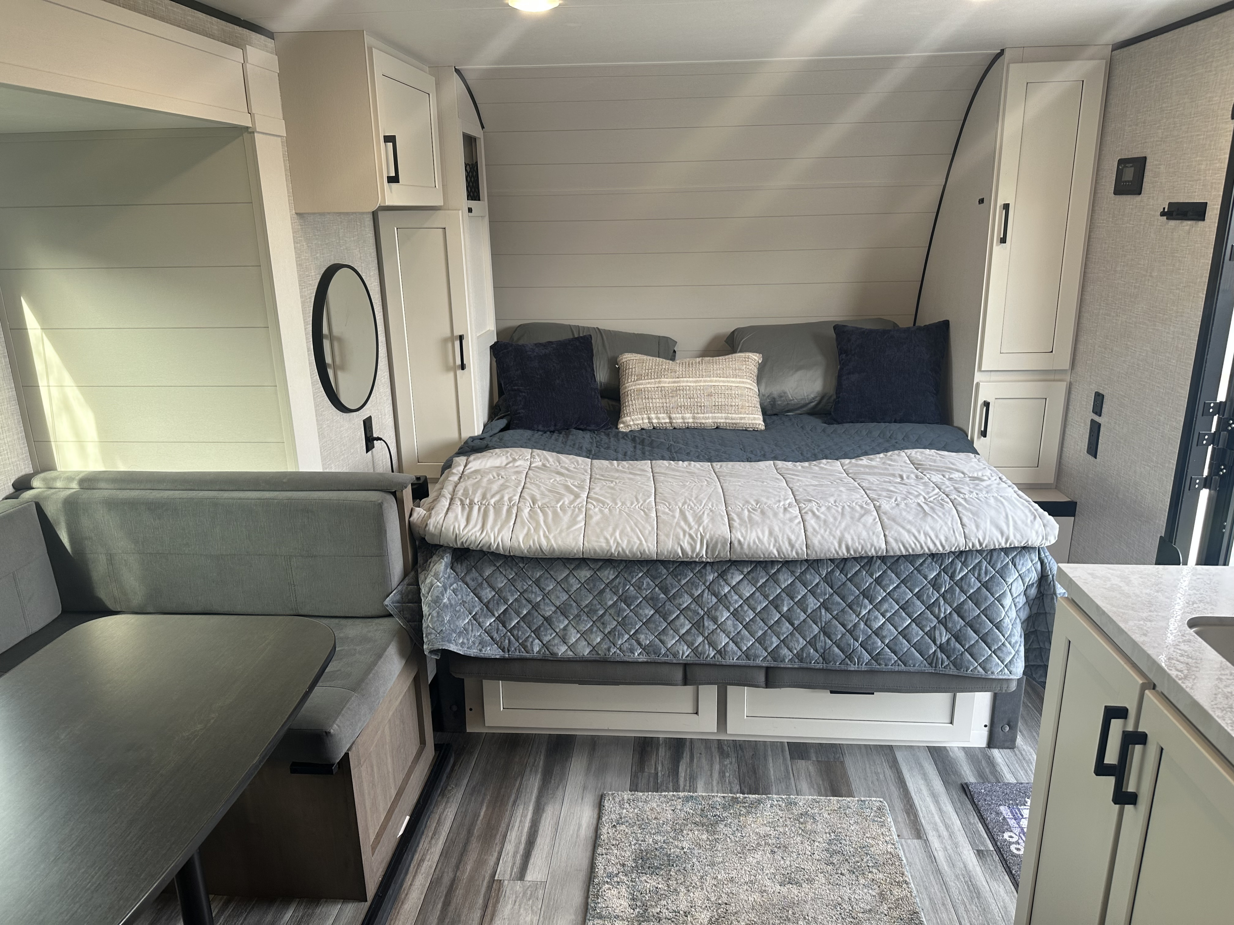 This RV rental's inviting interior features a comfortable bed, overhead storage, and a compact dinette area.. JayCo Jay Flight Baja Edition 2025