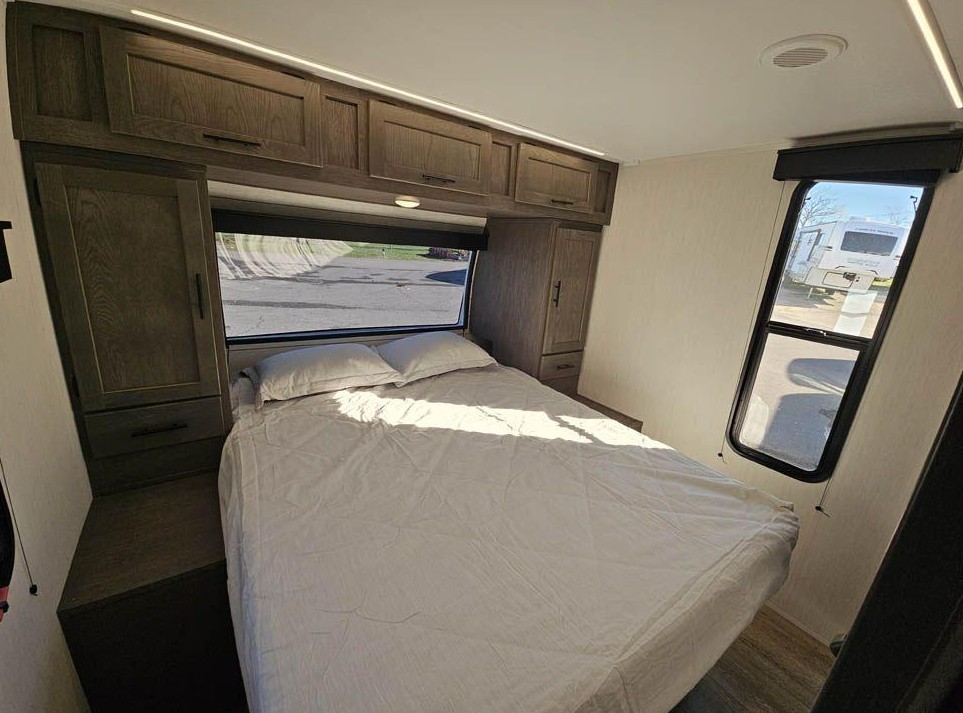 Bright and modern RV rental bedroom with a comfy bed, ample storage, and scenic windows for your travels.. Forest River Cherokee Alpha Wolf 2025
