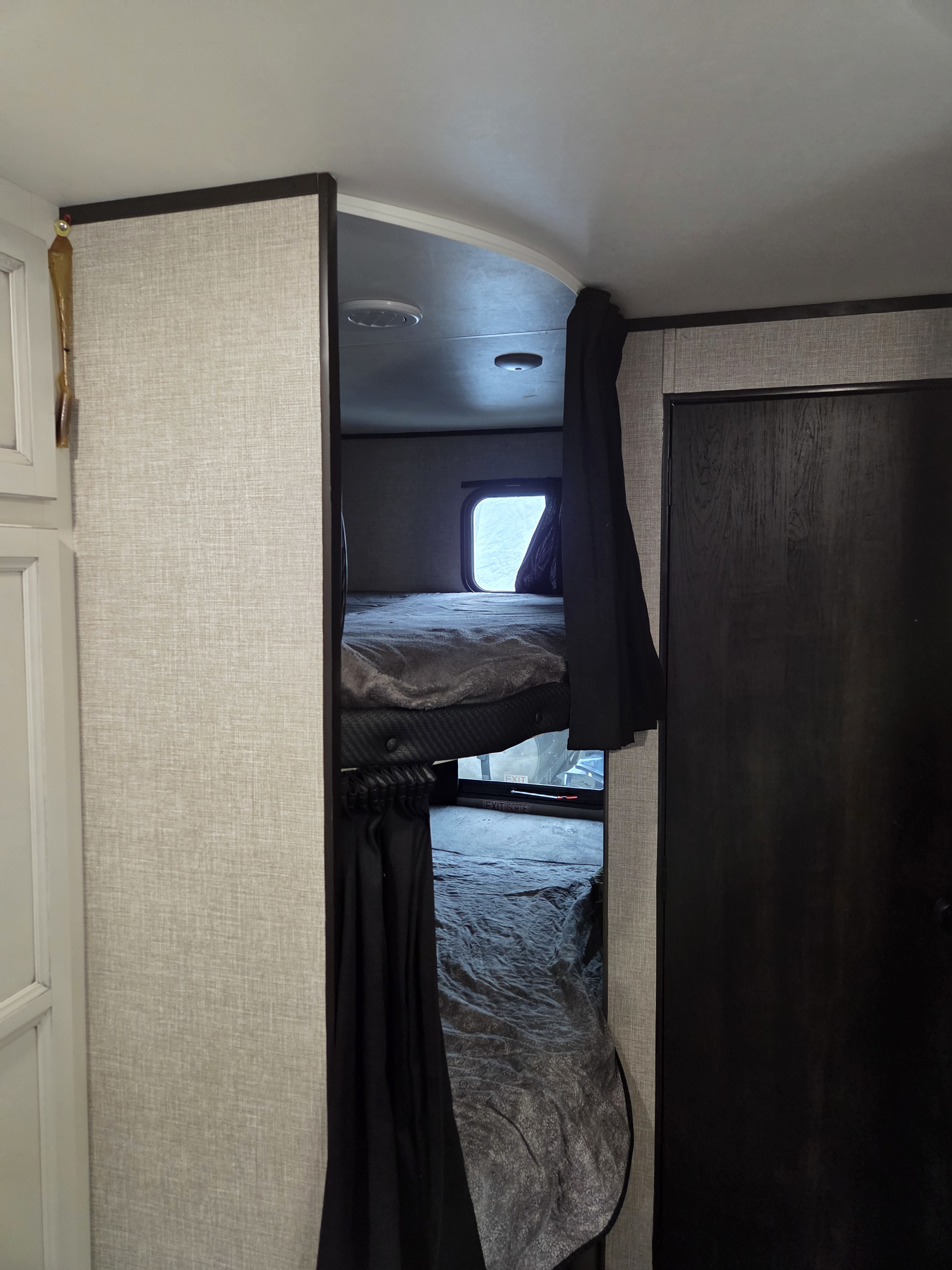 RV rental: Bunk bed area with dark privacy curtains, a window, and adjacent dark wood door. A cozy sleeping space.. Jayco Jay Flight SLX Rocky Mountain Edition 2022