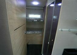 **RV rental** interior: view of bunk beds in a narrow sleeping area, next to a compact bathroom with a sink.. Chausson 720 VIP Titanium 2021