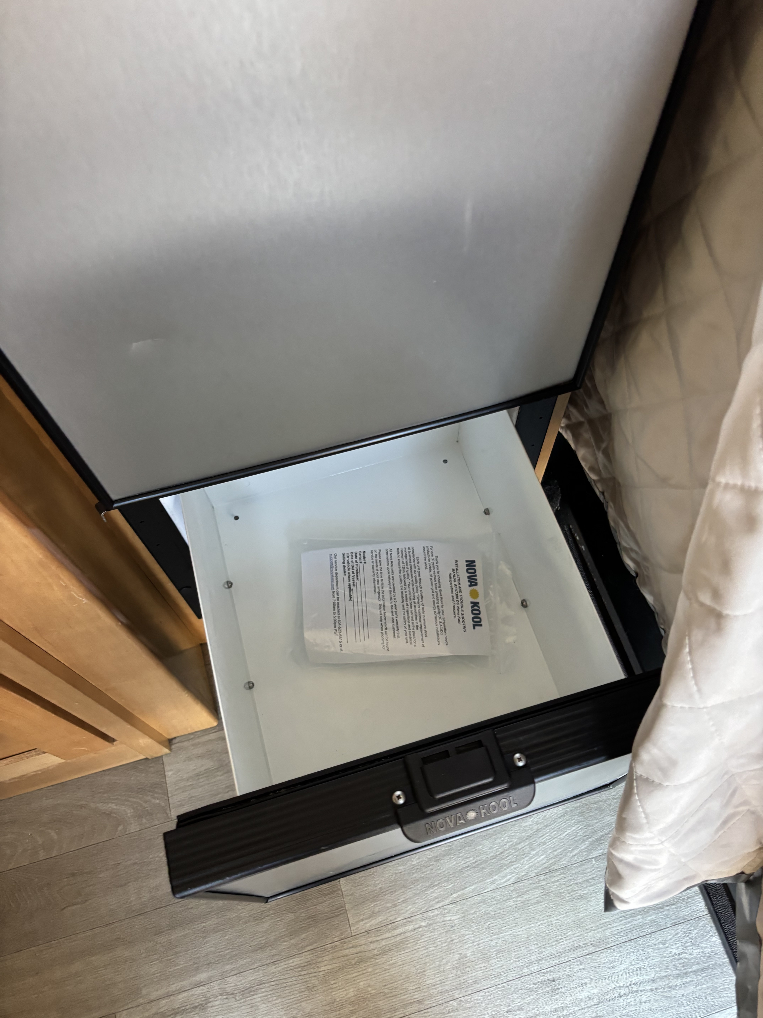 Drawer-style Nova Kool refrigerator in an RV rental, with its instruction manual inside, ready for mobile adventures.. Coachmen NOVA 20D 2024