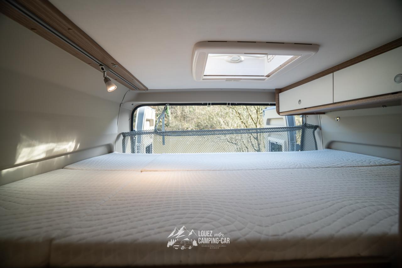 This RV rental offers a comfortable sleeping area with a large bed, overhead storage, skylight, and scenic window view.. CARADO CV 601 2021