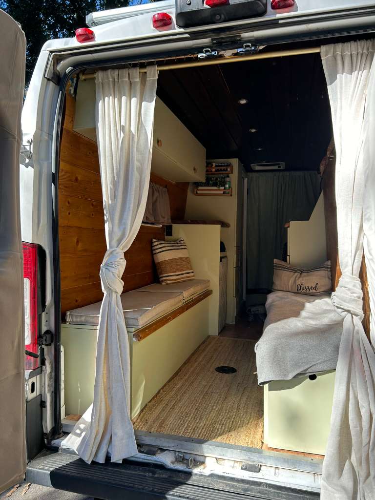 Explore the comfortable, custom interior of this camper van, ready for your rv rental journeys with cozy benches & storage.. RAM Promaster 2019