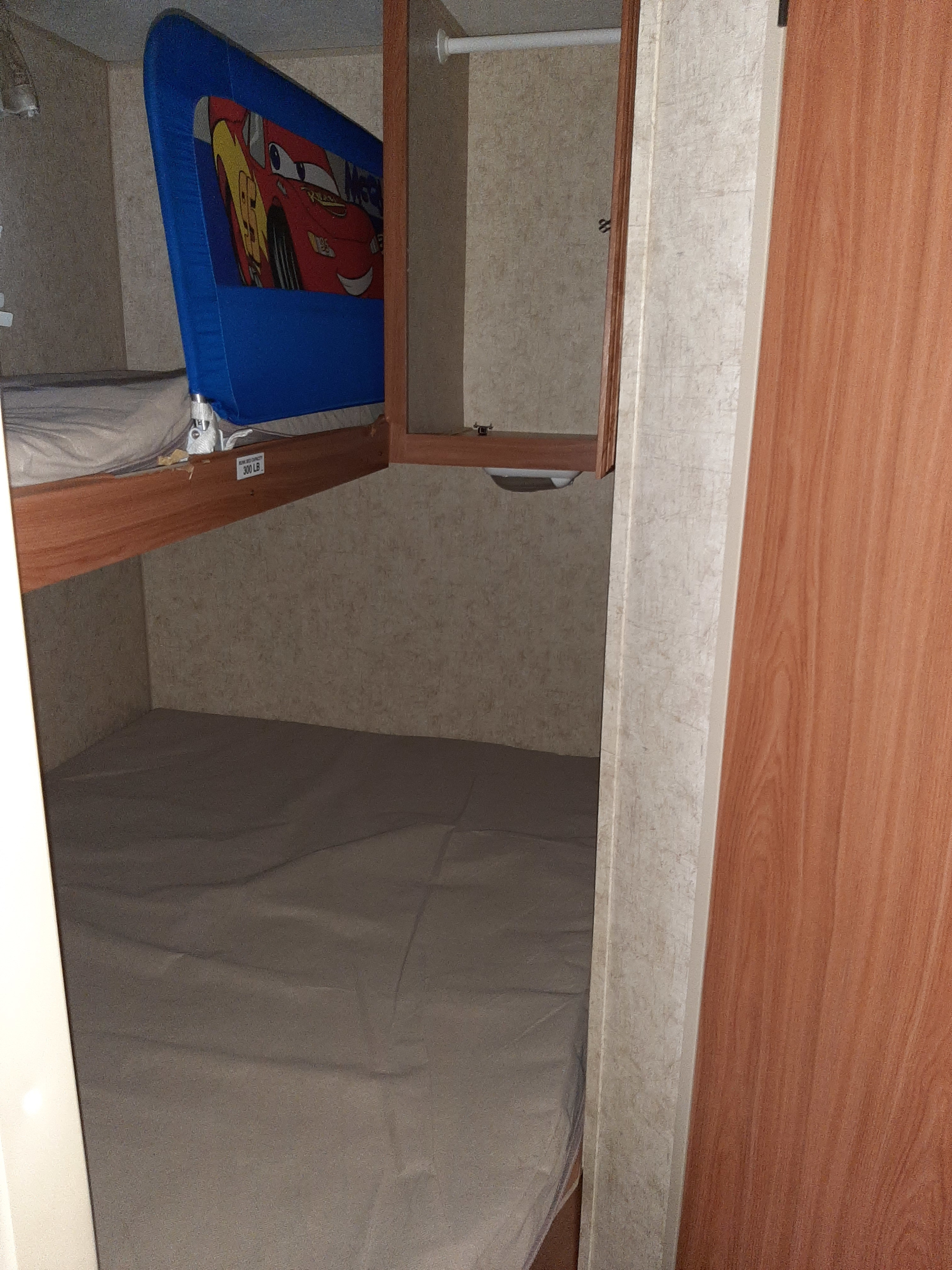 RV rental interior: cozy bunk beds with a fun Lightning McQueen rail, perfect for kids. Includes a small closet.. Four Winds Breeze SS 2010