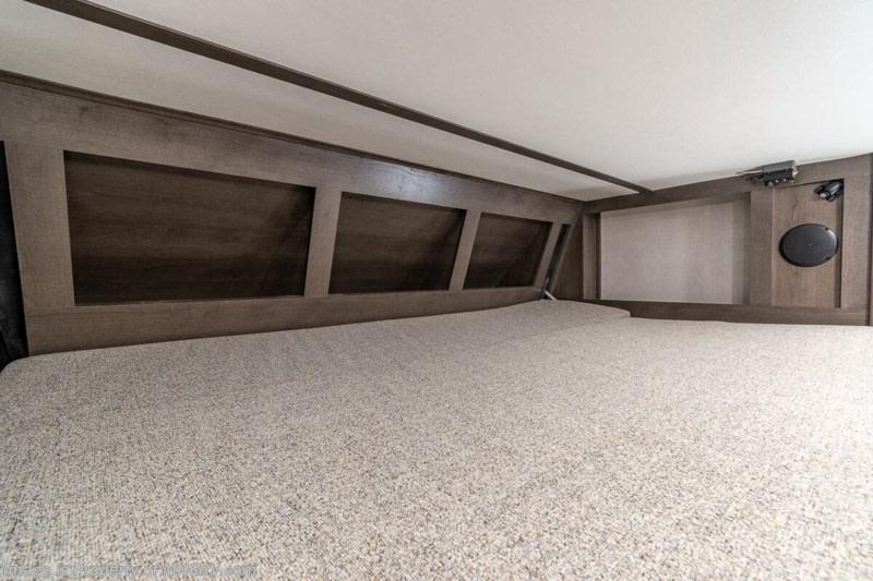 An RV rental bunk bed features a light, textured mattress, dark wood paneling, an integrated speaker, and controls.. Georgetown GT3 2021