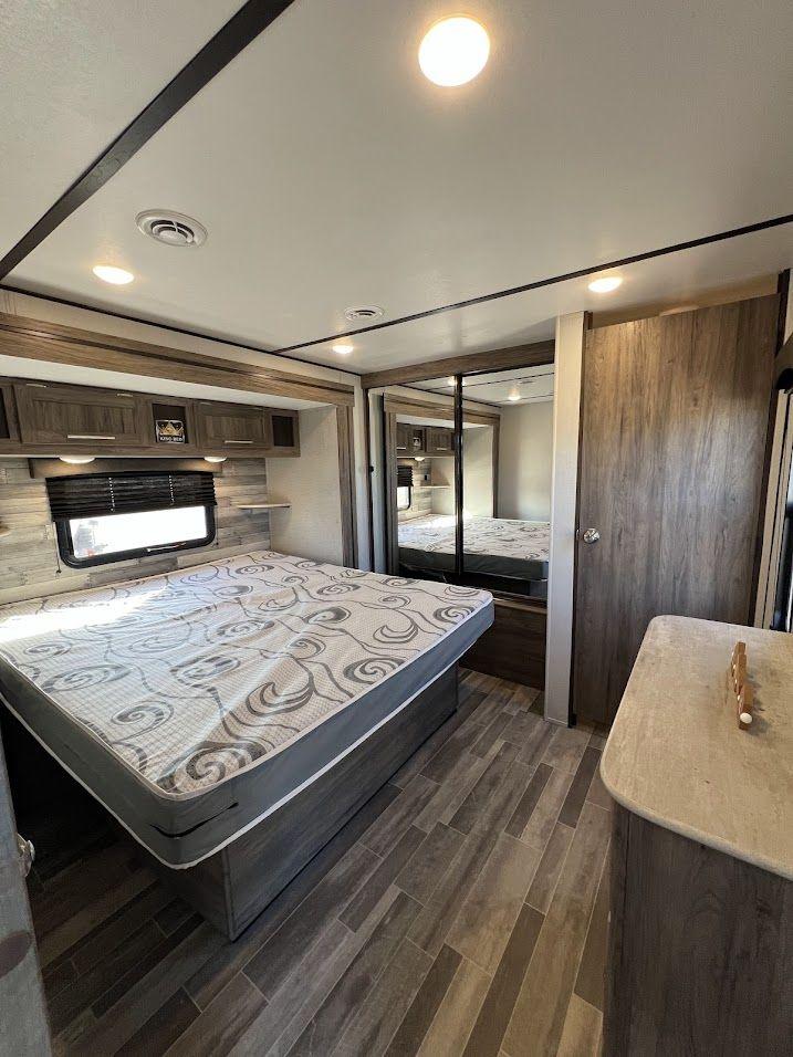Enjoy comfort in this modern RV rental bedroom. Features a large bed, ample storage, and mirrored wardrobe.. Crossroads RV Zinger 2021