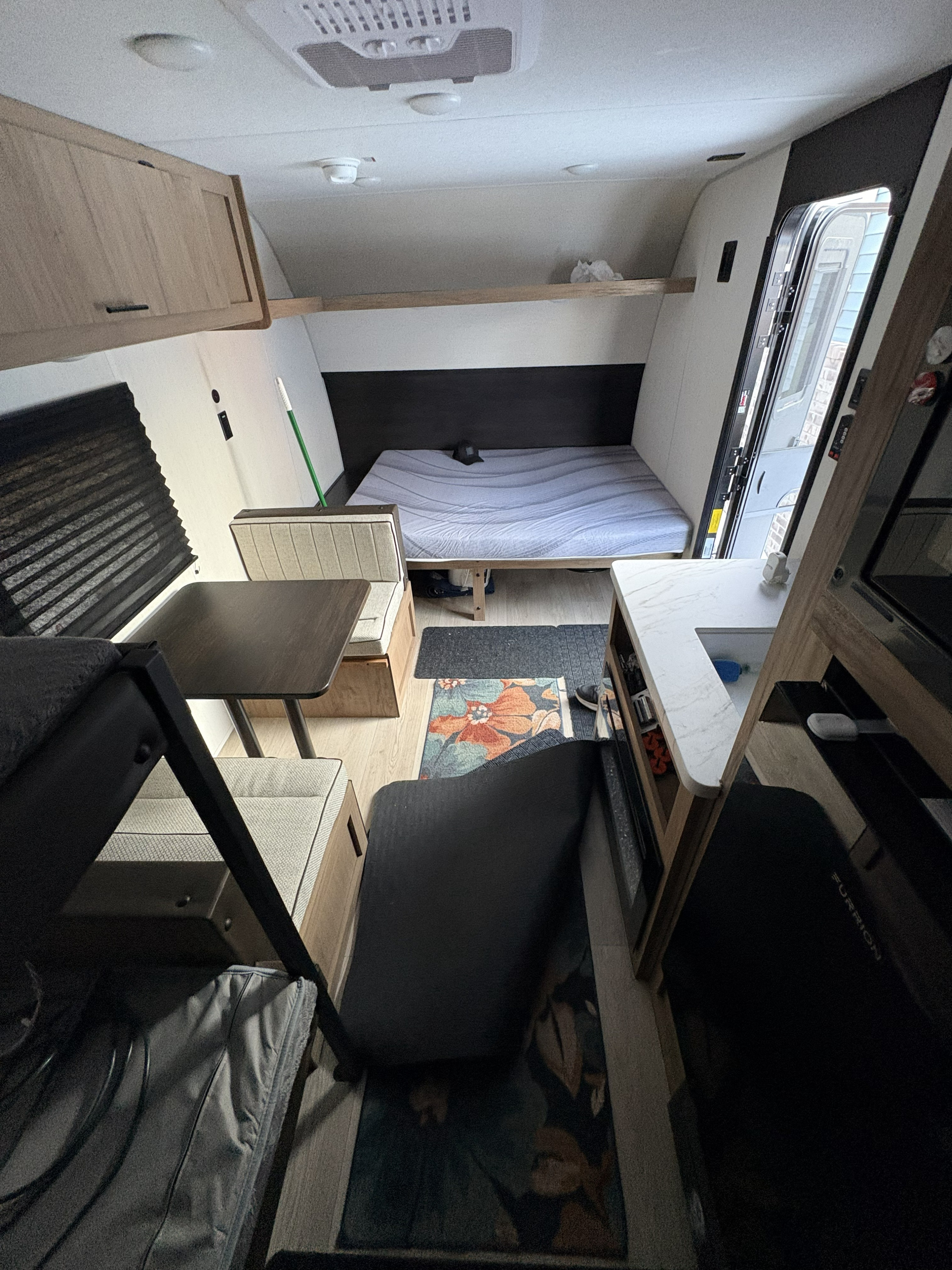 Cozy RV rental interior with dinette, bed, small kitchen, and bunk beds, offering a complete living space.. Forest River Cherokee Wolf Pup 2025