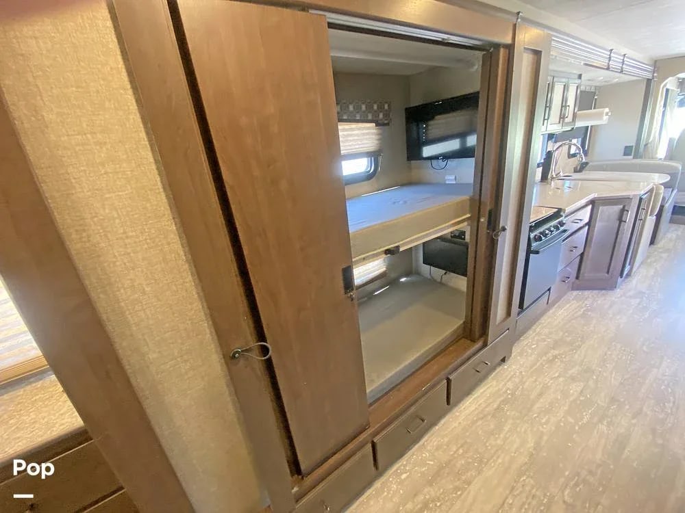 Spacious RV rental interior featuring comfortable bunk beds, a full kitchen with stove and sink, and practical living space.. Thor Hurricane 2017