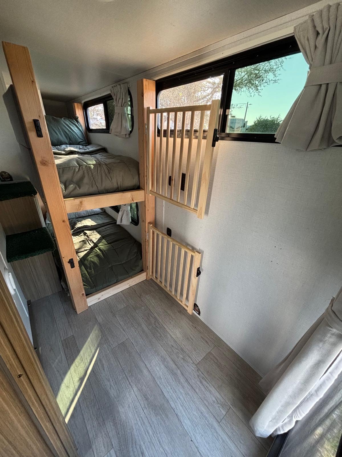 RV rental: Bunk beds with green bedding, wooden safety gates, and a ladder/steps in a bright RV interior.. Forest River Salem Platinum 2025