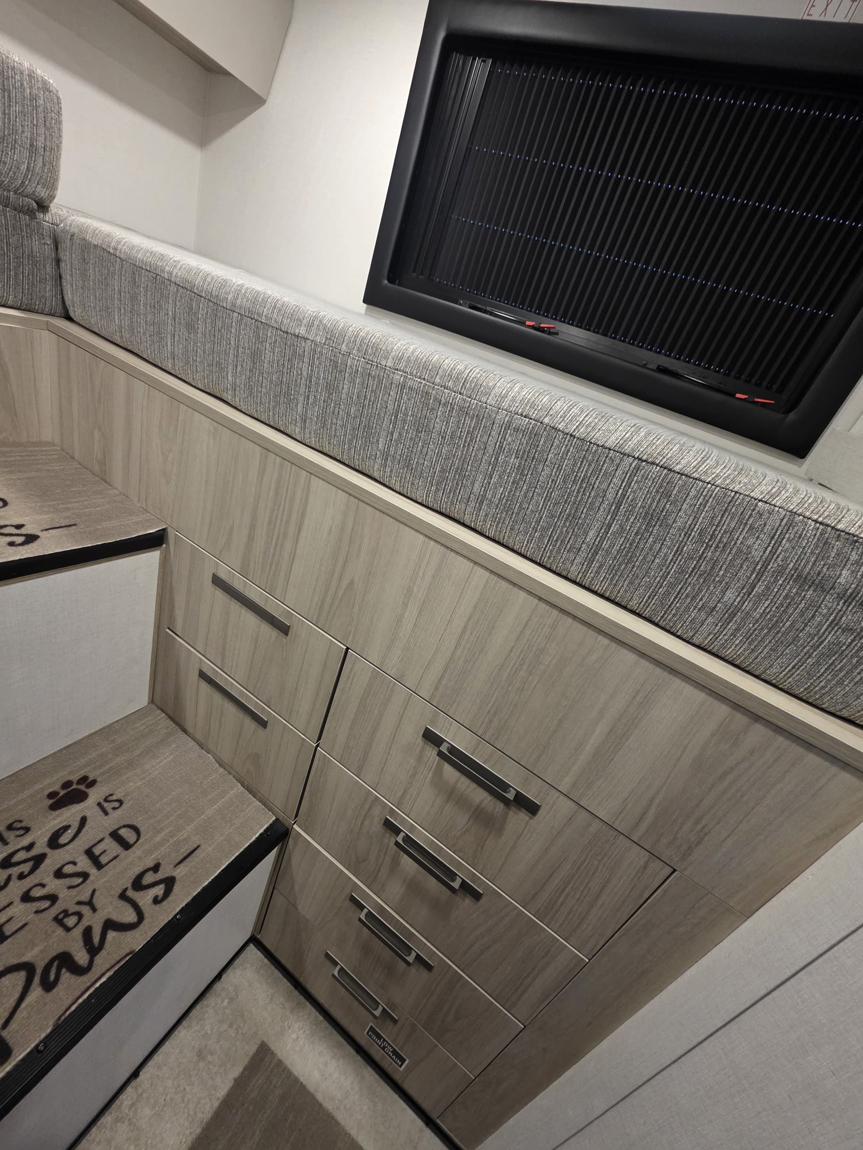 RV rental interior: Cozy bench seat with ample storage drawers, window, and pet-friendly steps with paw prints.. Forest River Coachmen Cross Trail EV 2026