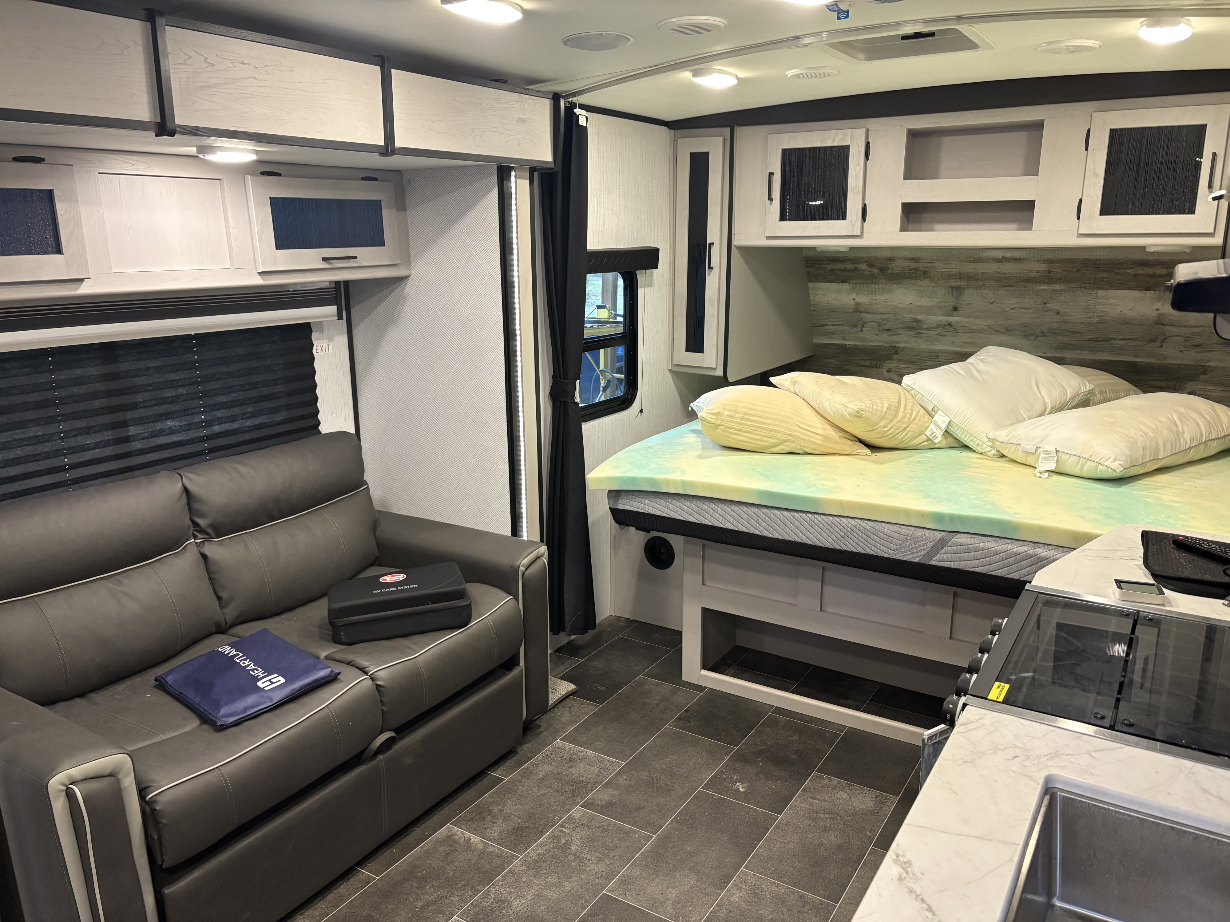 Modern RV rental interior featuring a cozy living area with a sofa, comfortable bed, and compact kitchen.. Heartland RVs Mallard 2022