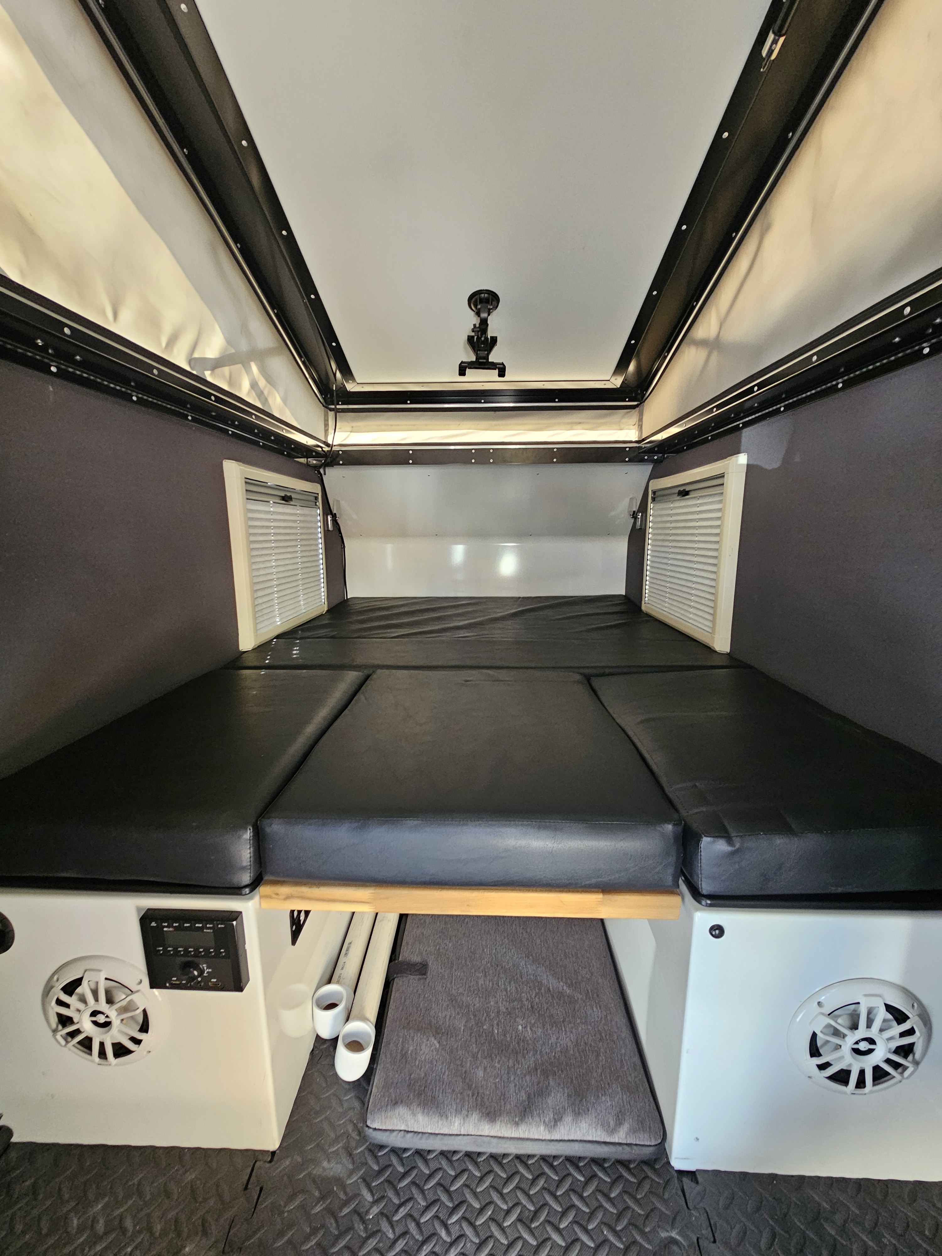 Inside a compact RV rental, featuring a comfortable convertible bed, pop-top roof, and integrated controls.. Mission Overland Mission Overland Trailer 2022