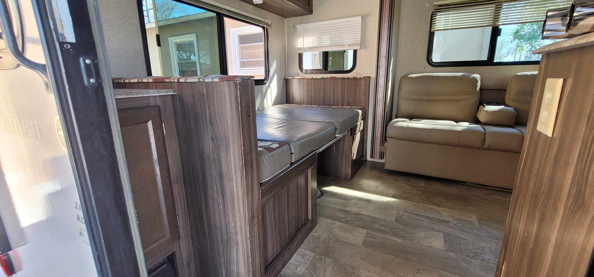 Sunny rv rental interior: dinette converts to bed, comfy seating, wood-grain cabinetry, and vinyl flooring.. Coachmen Apex Nano 2018