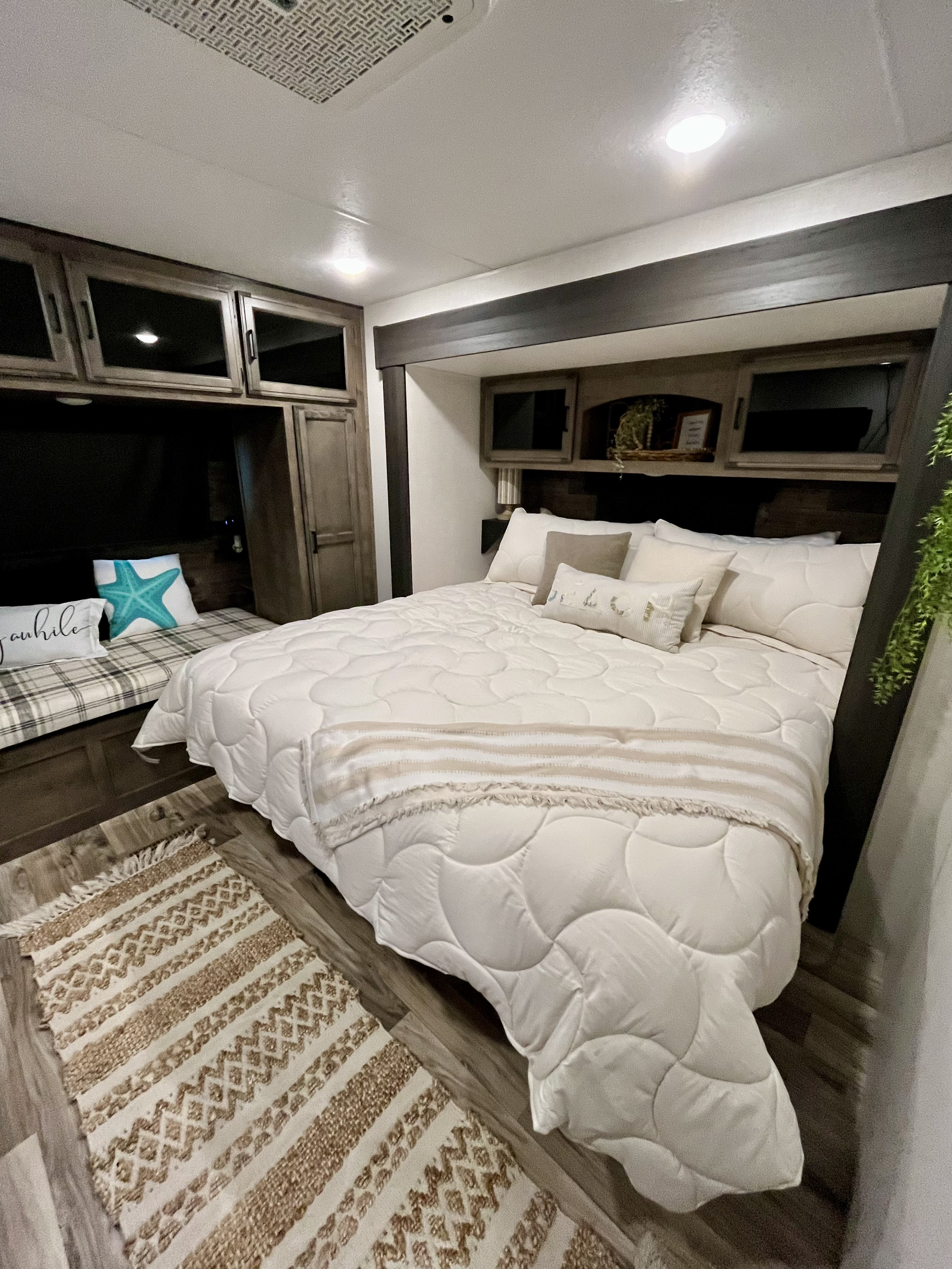 Stylish RV rental bedroom interior featuring a comfortable bed, accent pillows, and ample built-in storage.. Sporttrek Touring Edition 2024