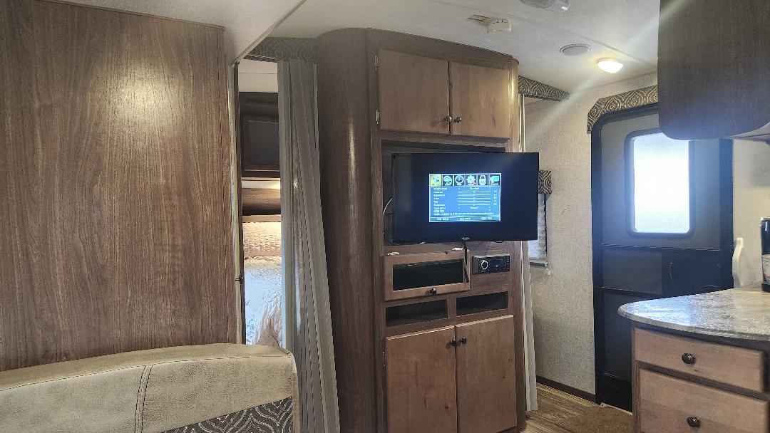 Explore this RV rental's cozy living area with TV, entertainment unit, bedroom access & entry door.. Nash Nash Trailer 2021