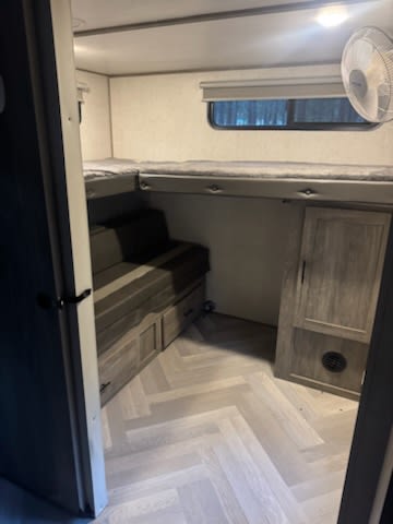 This RV rental offers cozy bunk beds, light herringbone flooring, and smart storage. Ideal for family travel.. Forest River Wildwood Lamitated Towables 2021