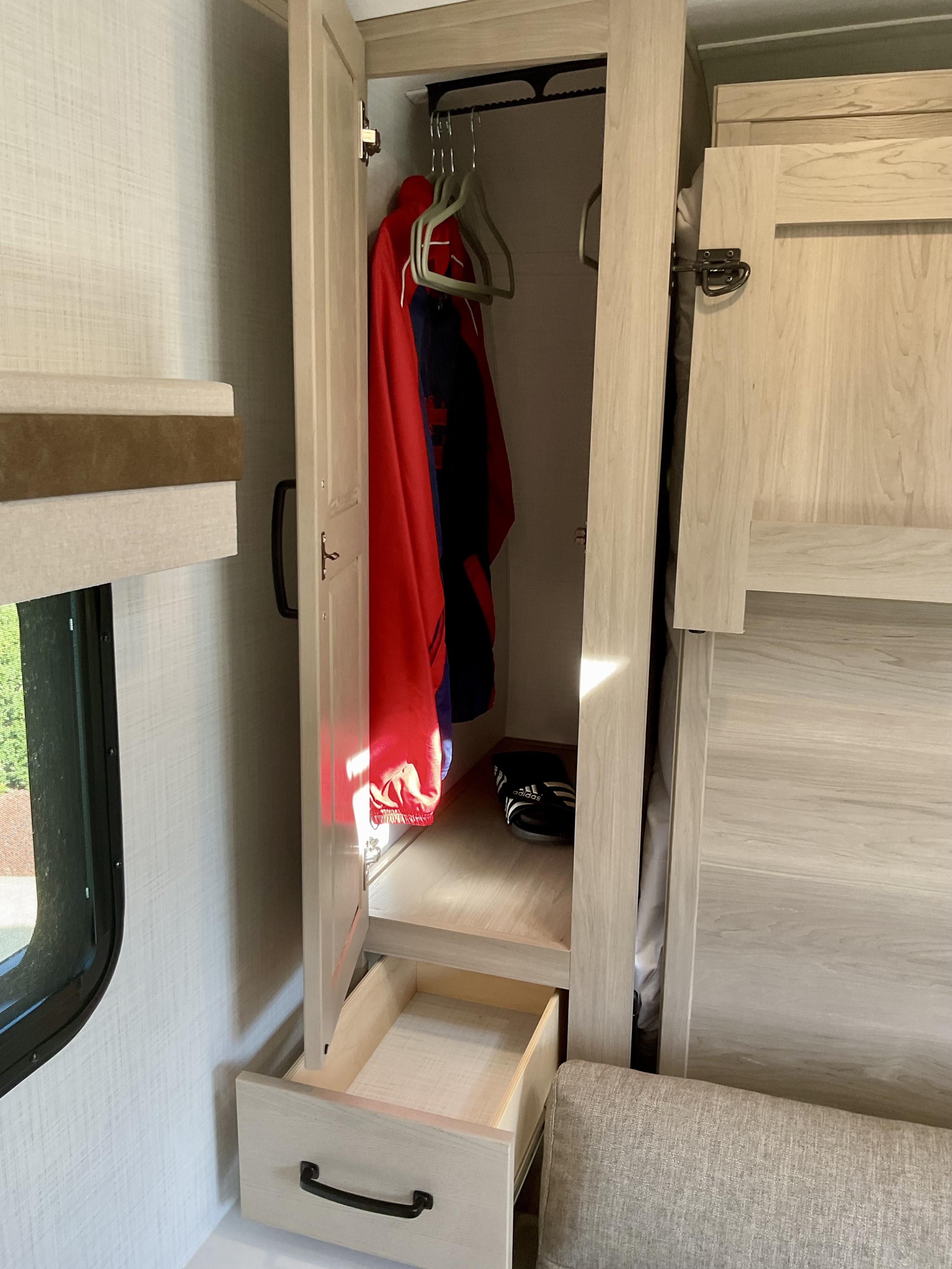 RV rental: Small closet with a red jacket, Adidas slides, and open drawer within a light-wood interior.. Forest River Rockwood Mini Lite 2024