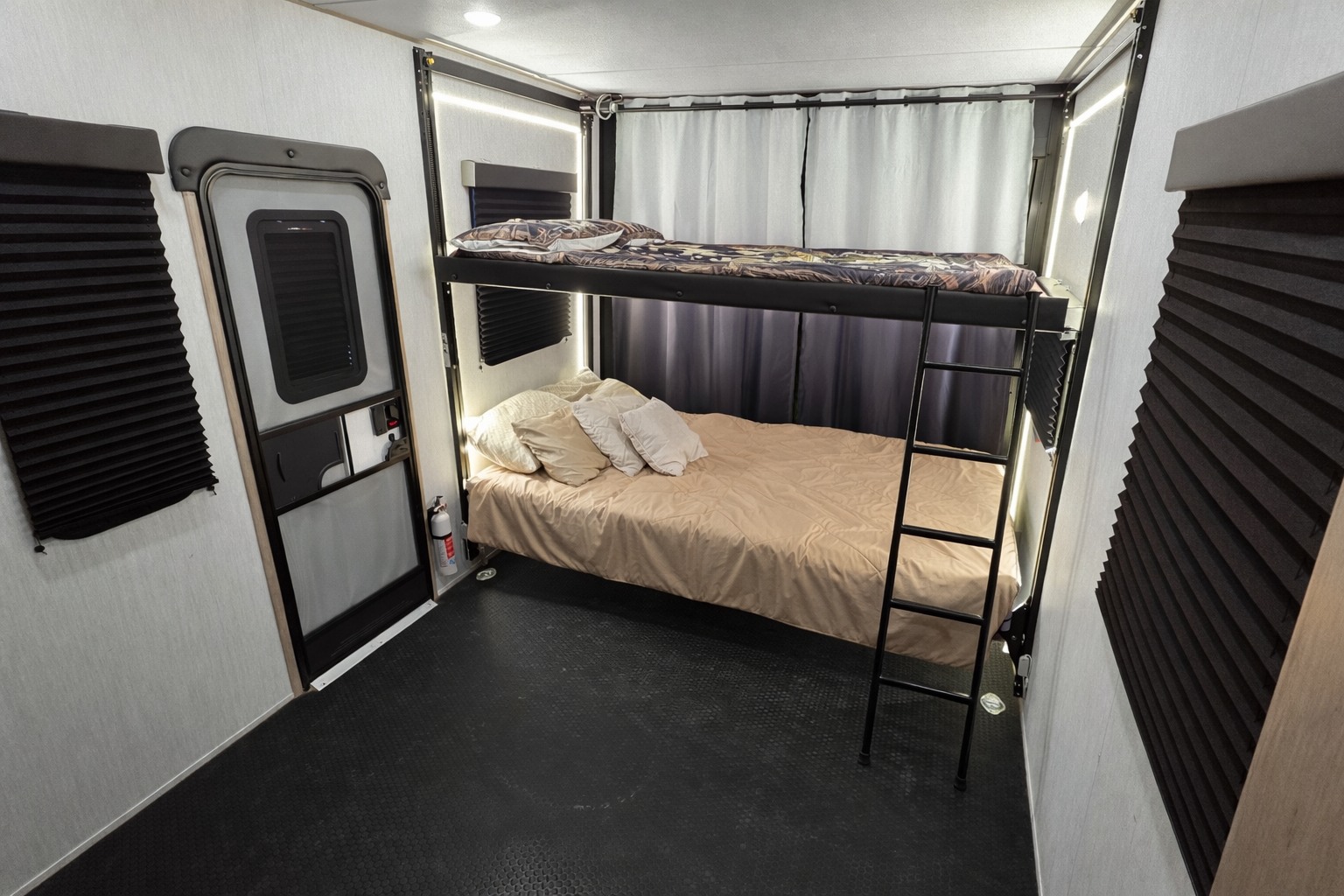 This rv rental features a cozy bunk bed setup with a lower double bed, upper twin, and a rugged floor, ideal for family travel adventures.. Grand Design Momentum 2023