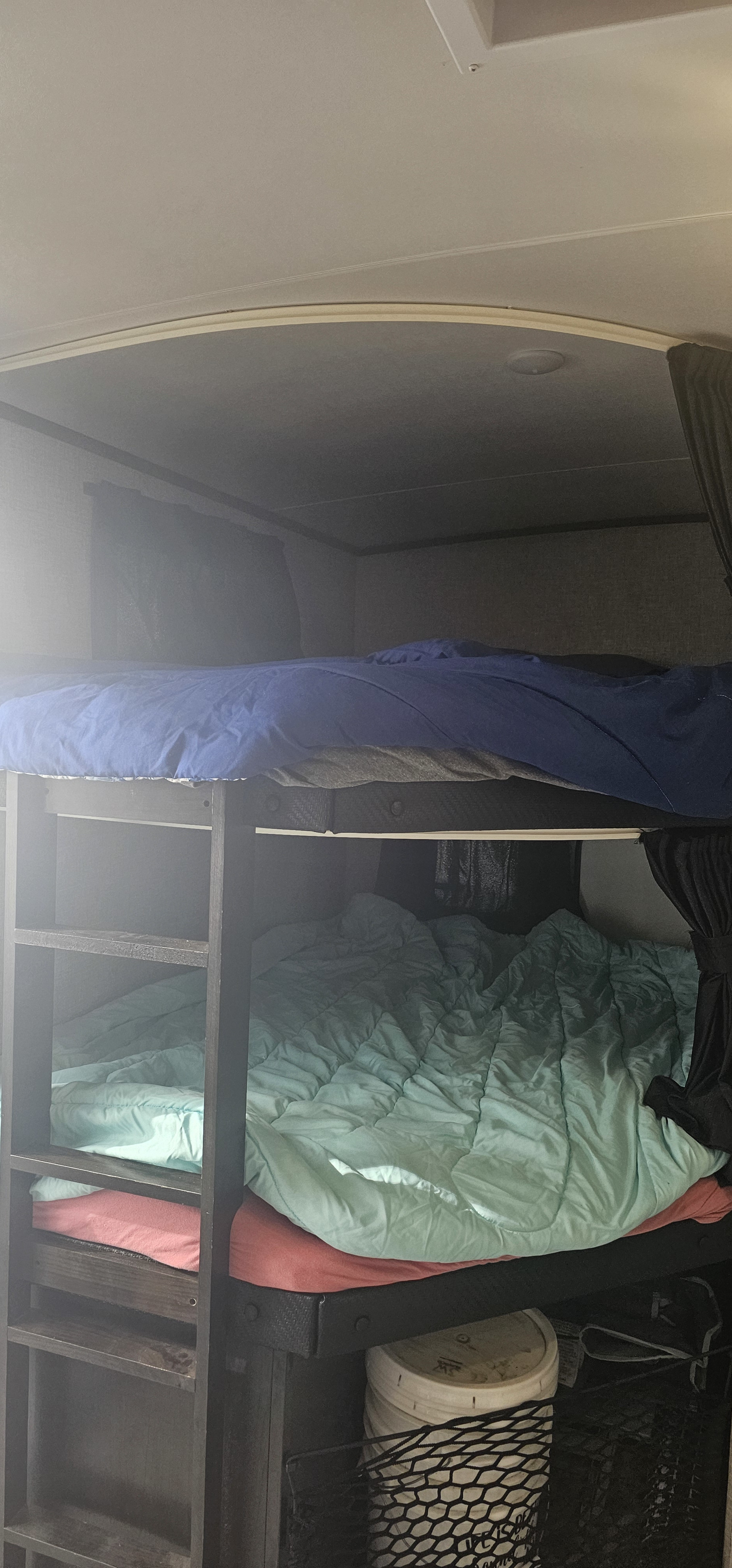 Cozy RV rental bunk beds with blue and teal bedding, featuring a ladder and storage, ready for family adventures.. Jayco White Hawk 2022
