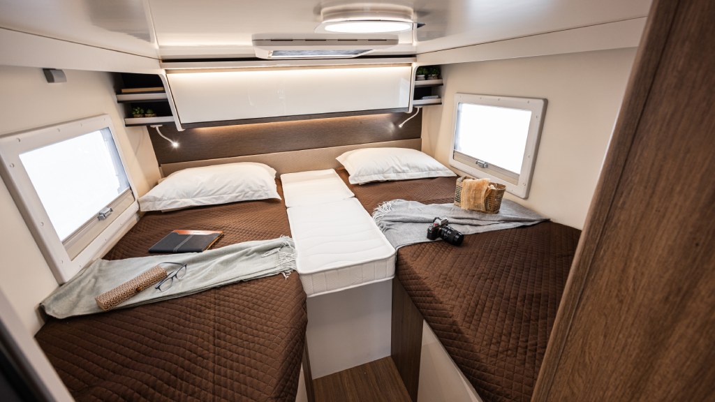 Cozy rv rental bedroom with twin beds, a convertible middle mattress, windows, and overhead storage for a comfortable journey.. Elnagh baron 539 2023