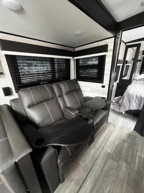 Modern RV rental interior with comfy recliners, snack trays, and stylish flooring. Perfect for relaxing.. Jayco White Hawk 2022