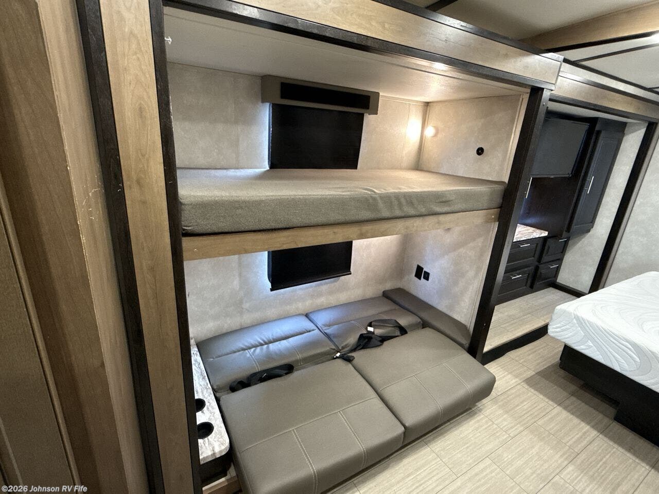 This RV rental offers a versatile bunk bed area. An upper bunk and a lower one with a sofa-like cushion that converts to seating are visible.. FR3 FR3 Motorhome 2022