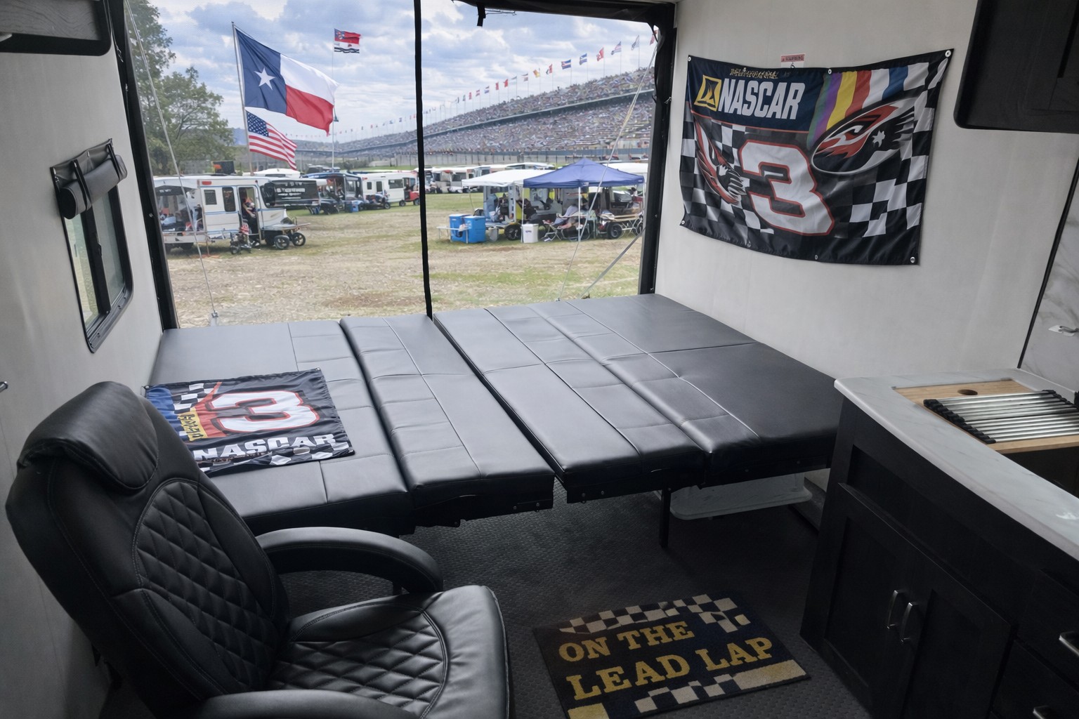 RV rental interior: NASCAR-themed beds & decor with a trackside view of grandstands, flags, and camping, perfect for race fans.. Work and Play Toy Hauler 2024
