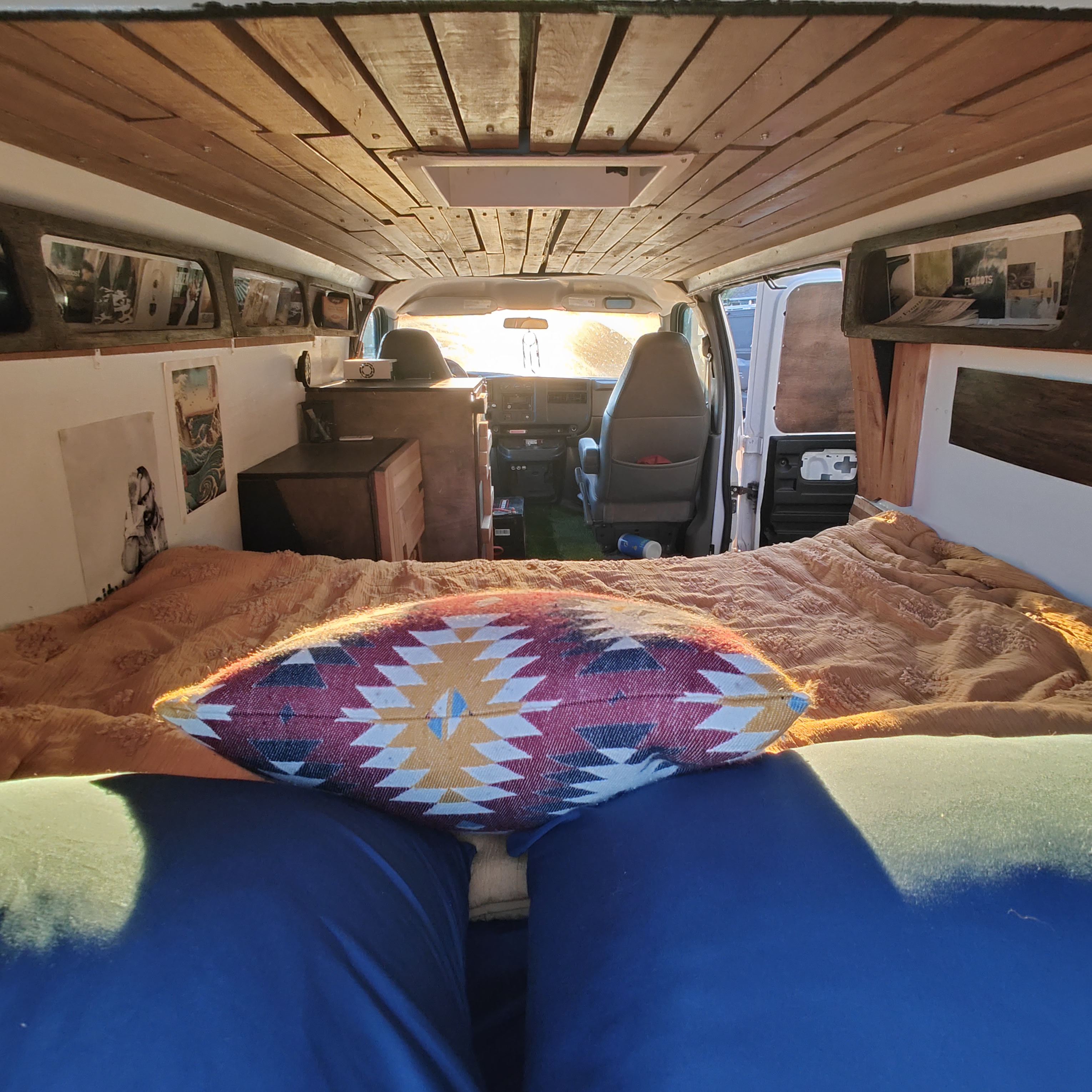 Cozy custom camper van interior featuring a patterned pillow on the bed, looking towards the front cabin. Perfect for RV rental.. Chevrolet CHEVY EXPRESS 1500 2004