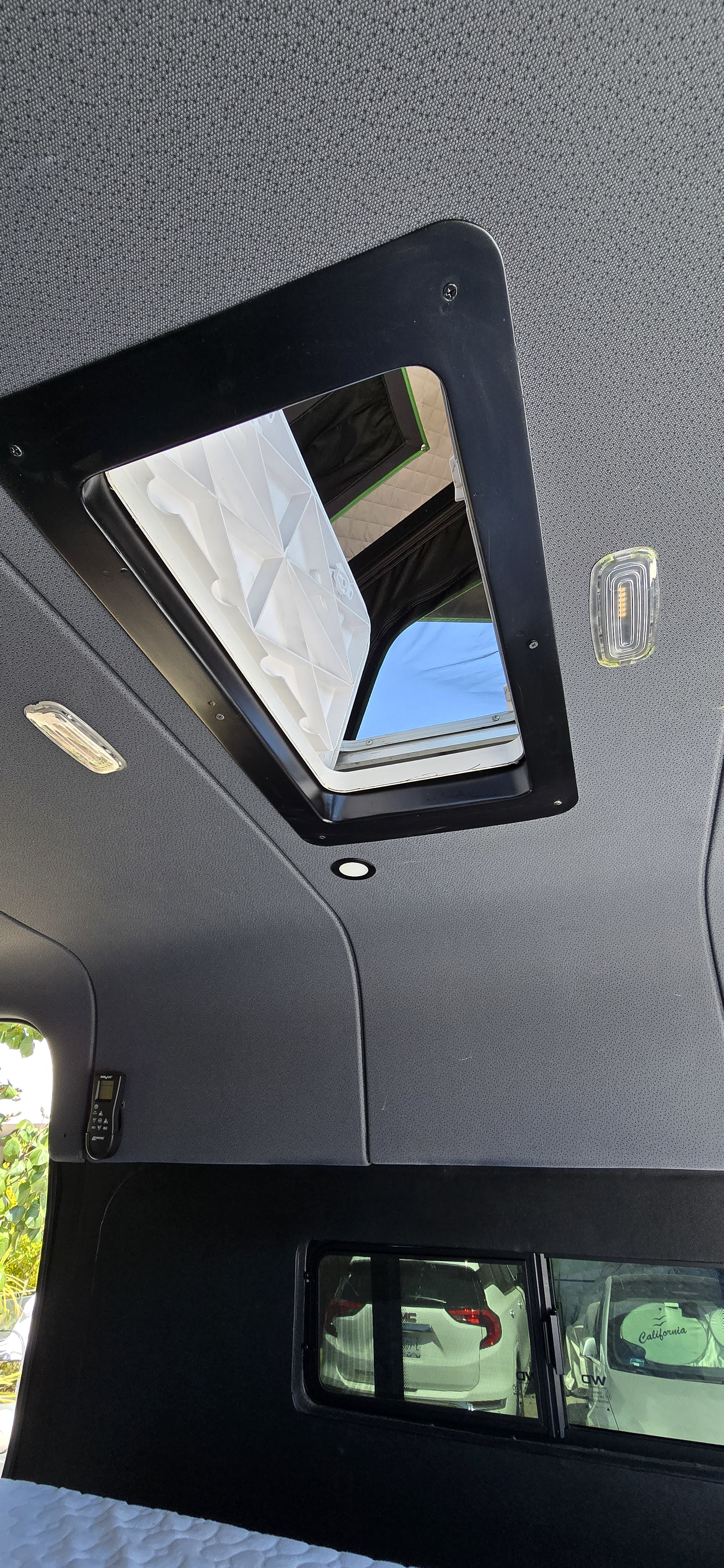 Inside your RV rental: a bright camper van ceiling with an open roof vent for fresh air and natural light.. Mercedes Sprinter 2023