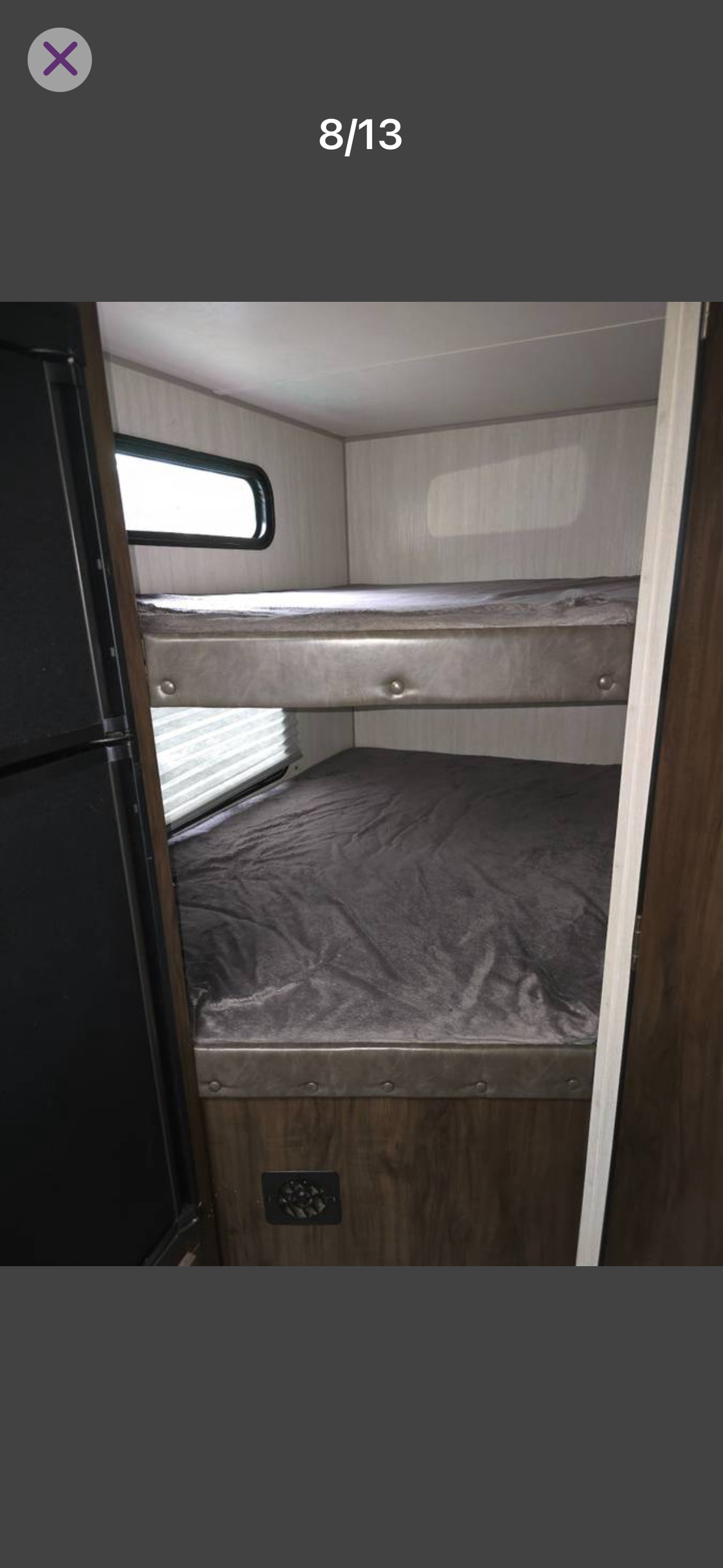 RV rental interior showing comfortable bunk beds with a window, next to a refrigerator.. Forest River Cherokee Grey Wolf 2019