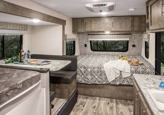 Cozy RV rental interior featuring a modern dinette, comfy bed, and convenient kitchen, ready for your next adventure.. KZ Sportsman classic 2023