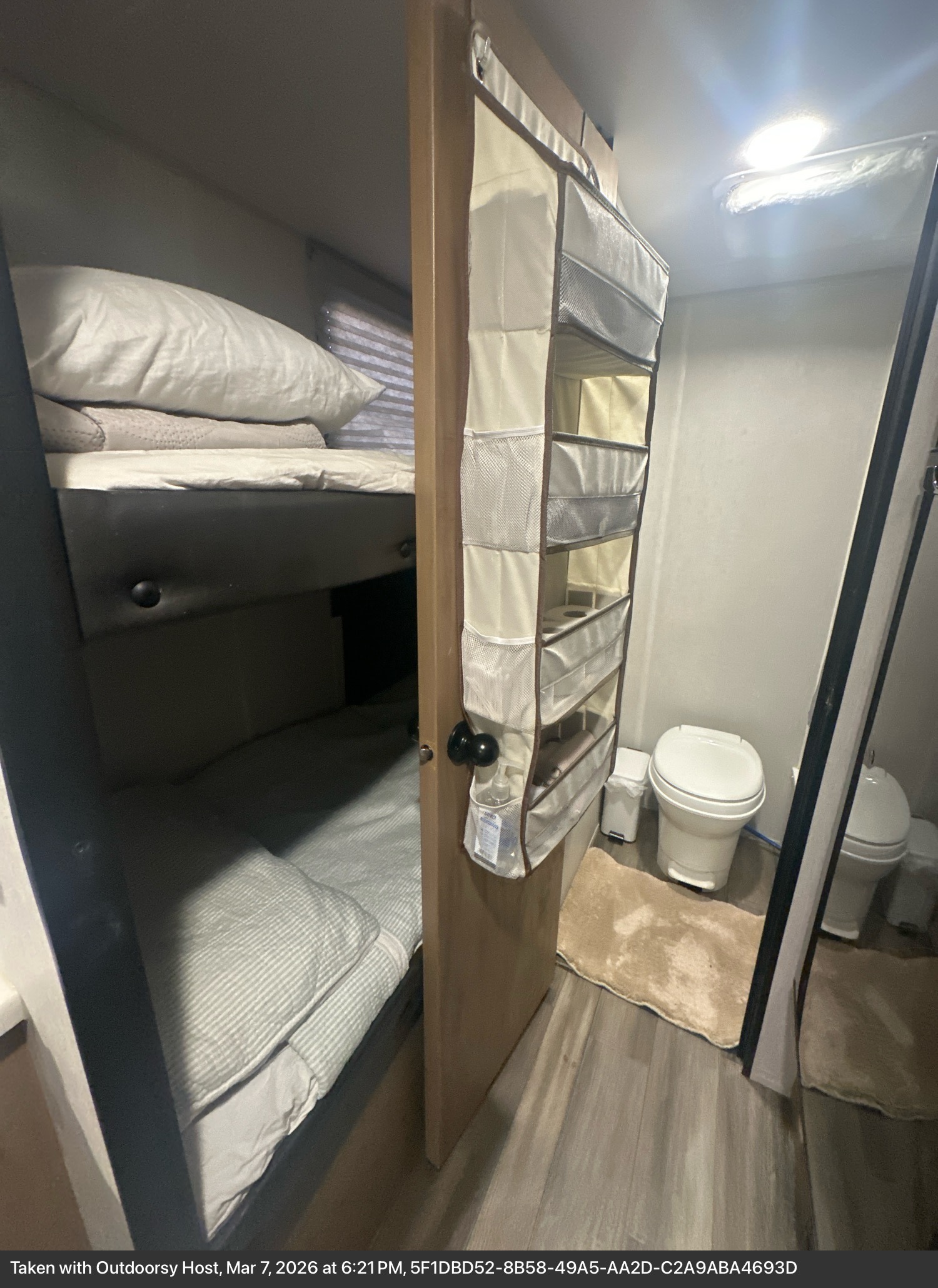 This RV rental features efficient bunk beds and a compact bathroom with a toilet, complete with hanging storage.. Forest River Cherokee Wolf Pup 2023
