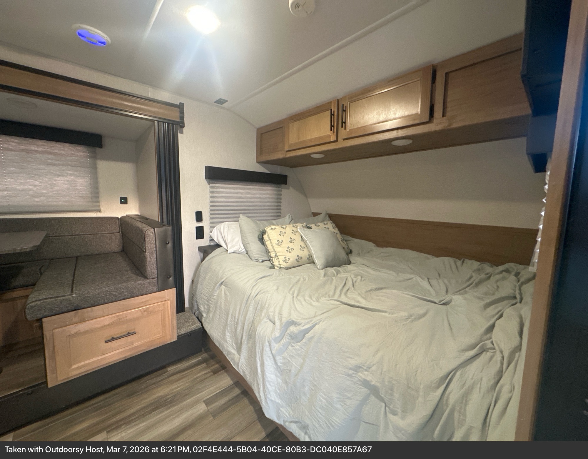 Cozy RV rental interior with a comfortable bed, wood cabinets, and an adjacent dinette, perfect for travel.. Forest River Cherokee Wolf Pup 2023