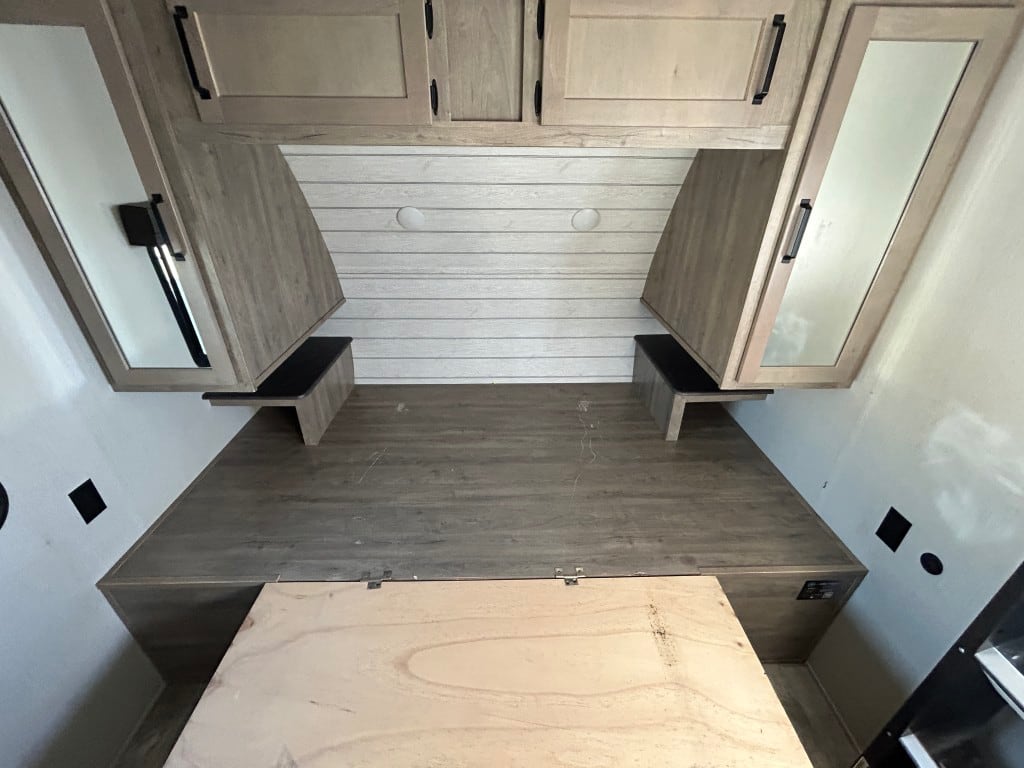 Check out this modern RV rental bed area: wood platform, shiplap headboard, and mirrored overhead storage cabinets.. Forest River Palomino Puma 2024